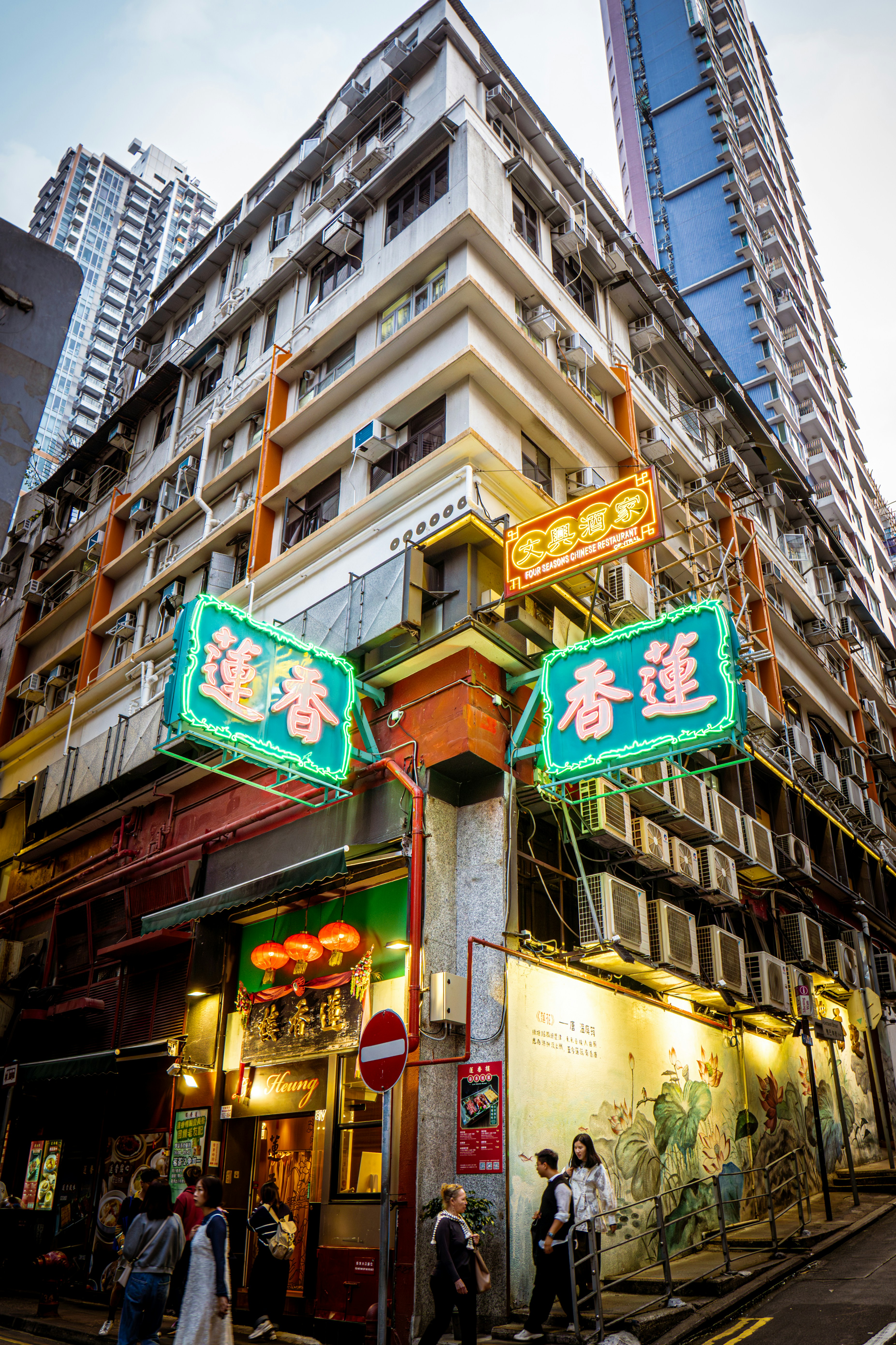 Neon signs illuminate a bustling hong kong street corner.