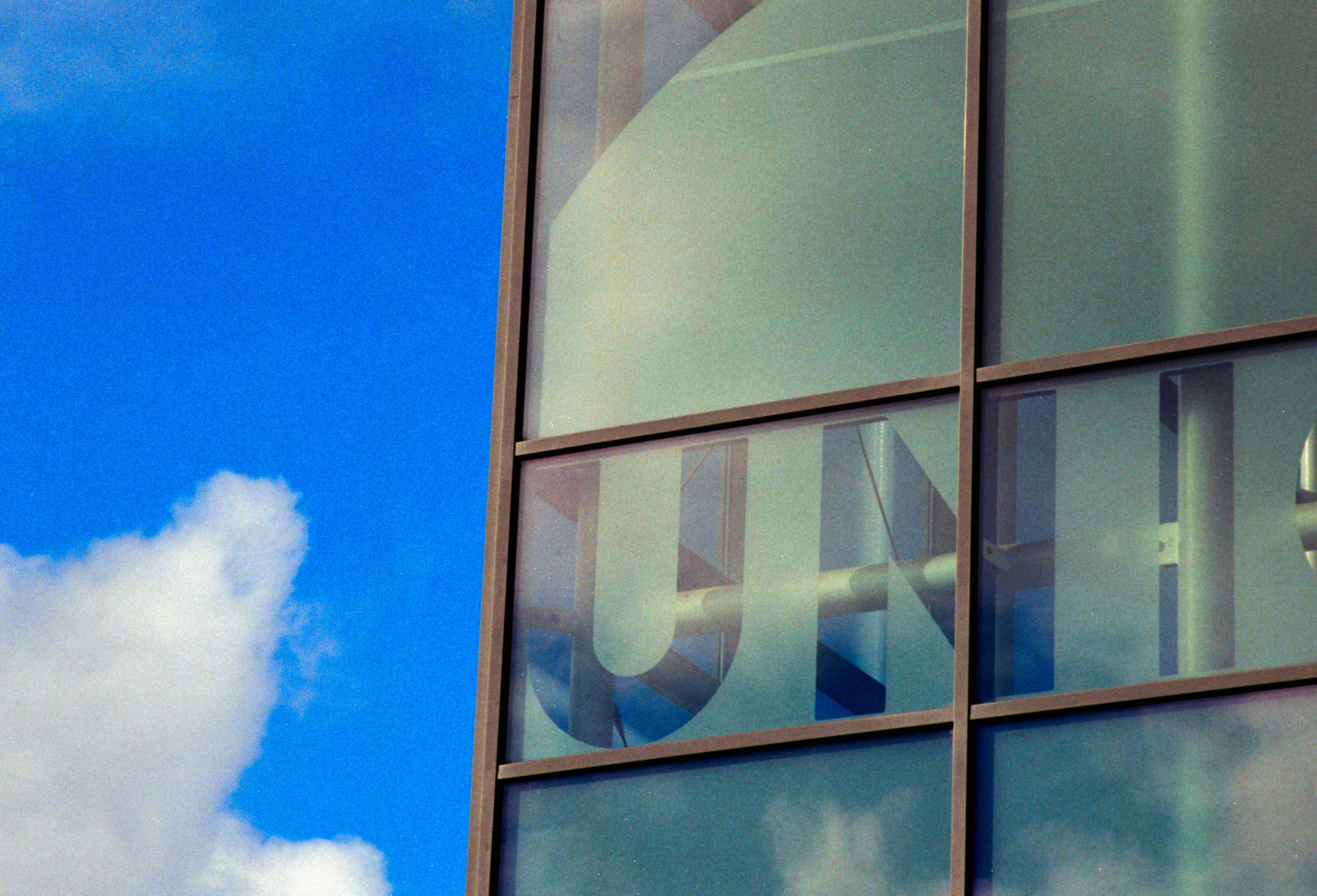 Building with 'un' on glass windows against blue sky.