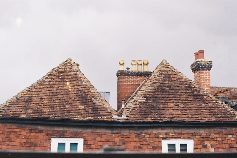 Residential rooftop brick chimneys and tiles maintained in safe operating condition