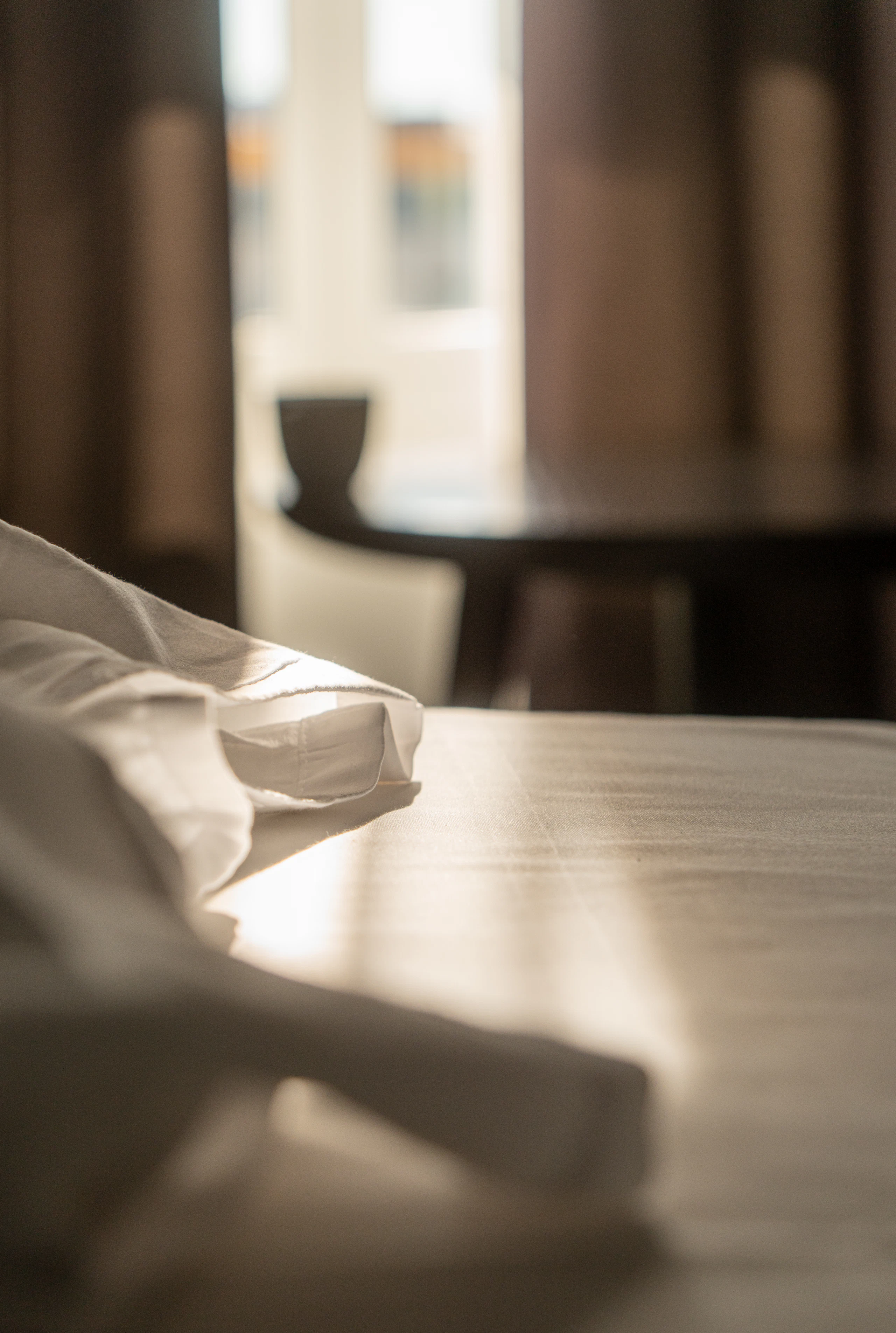 Linge de maison plié dans la lumière rasante d’une salle à manger