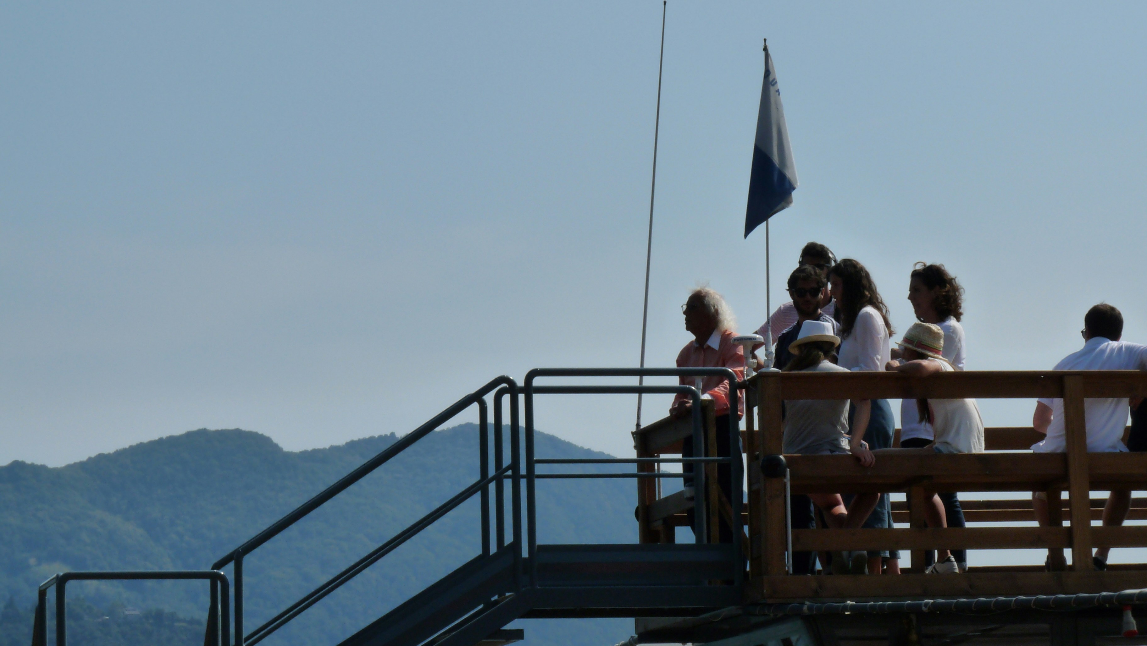 Group of people enjoying mountain views from an outdoor deck.