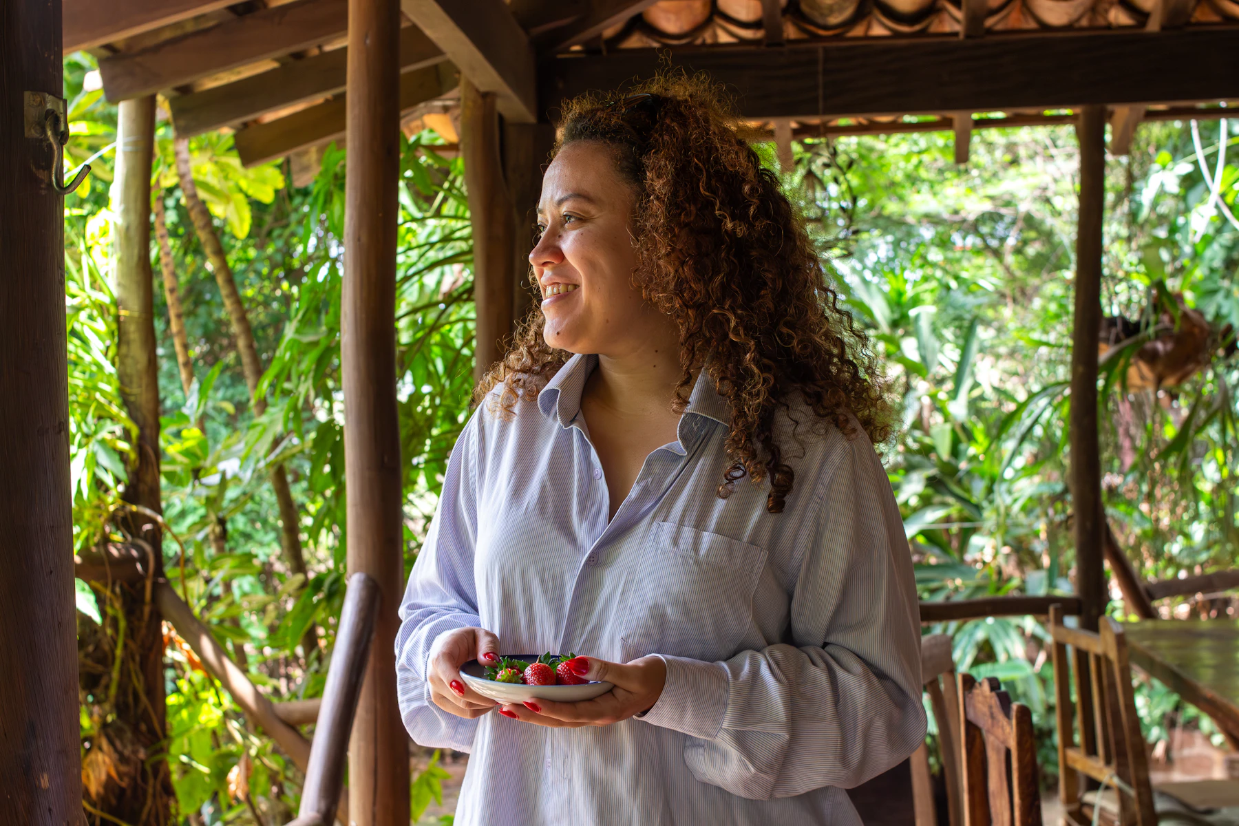 Mujer sonriente con fruta fresca en un entorno natural