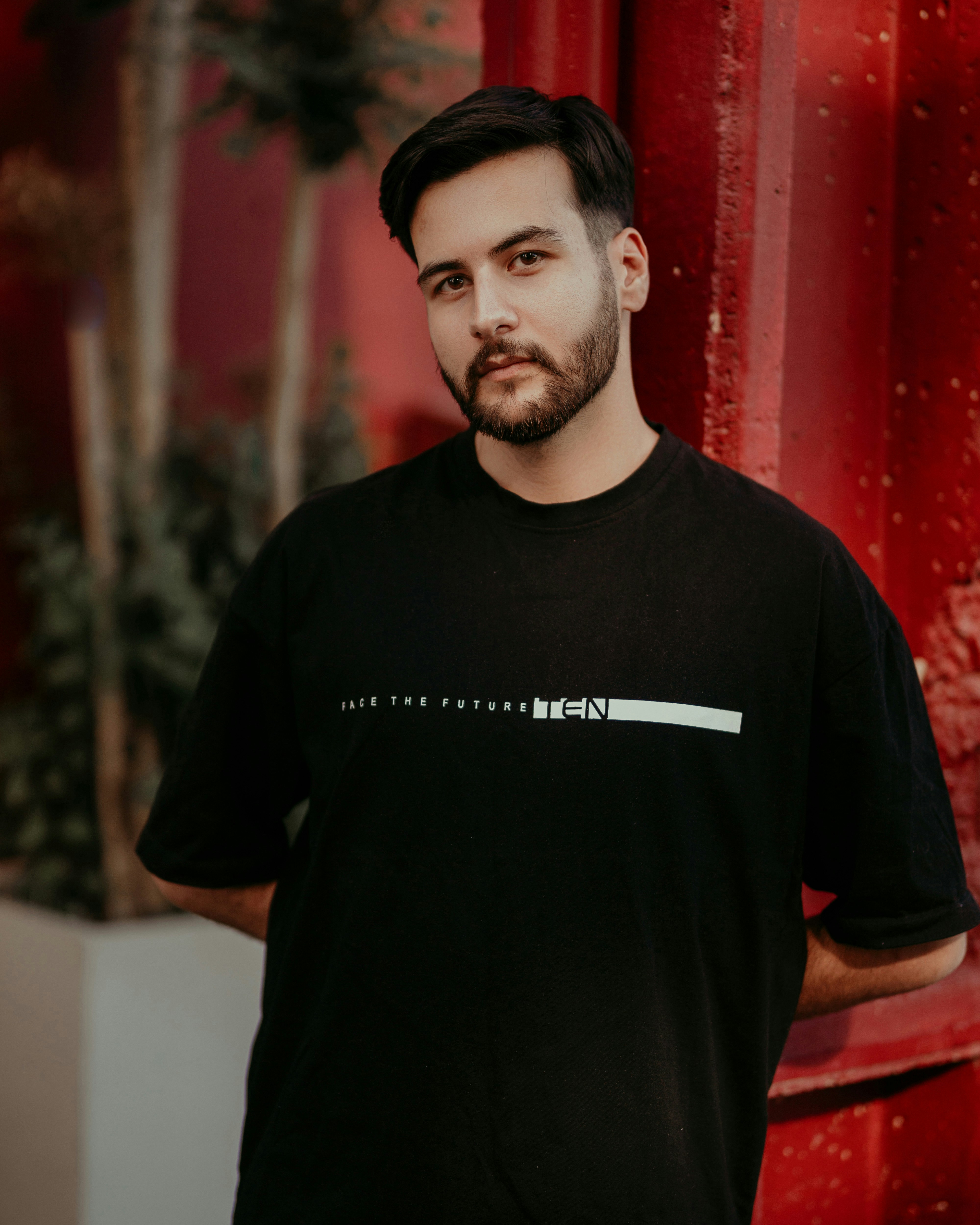 Bearded man in black t-shirt looking at the camera