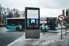 Digital billboard on a city street with a moving bus.