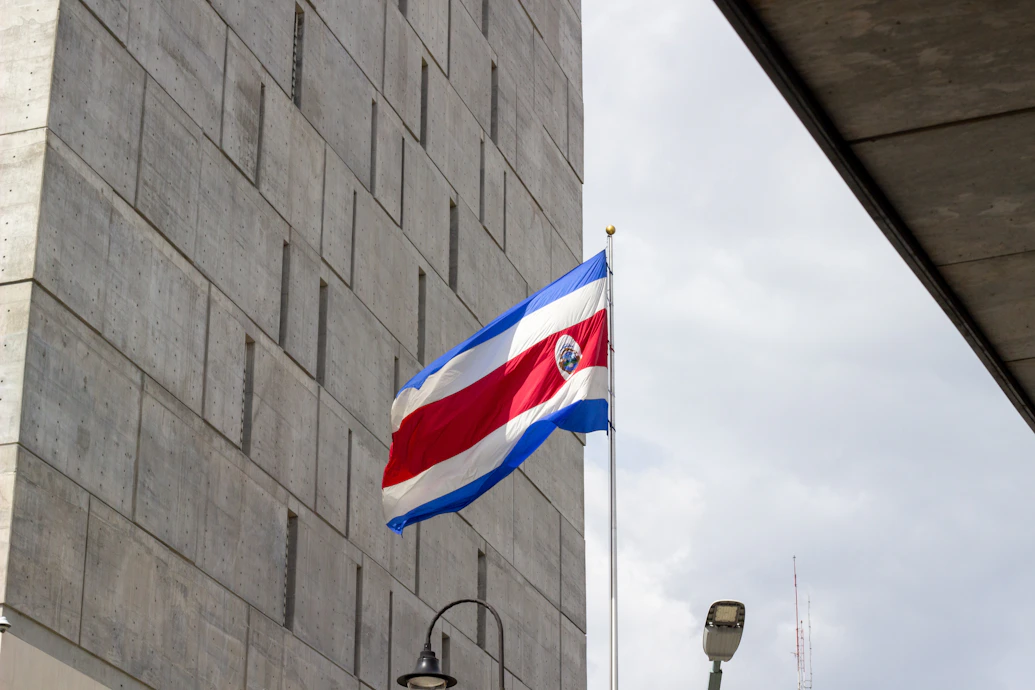 The costa rican flag flies proudly beside a modern building