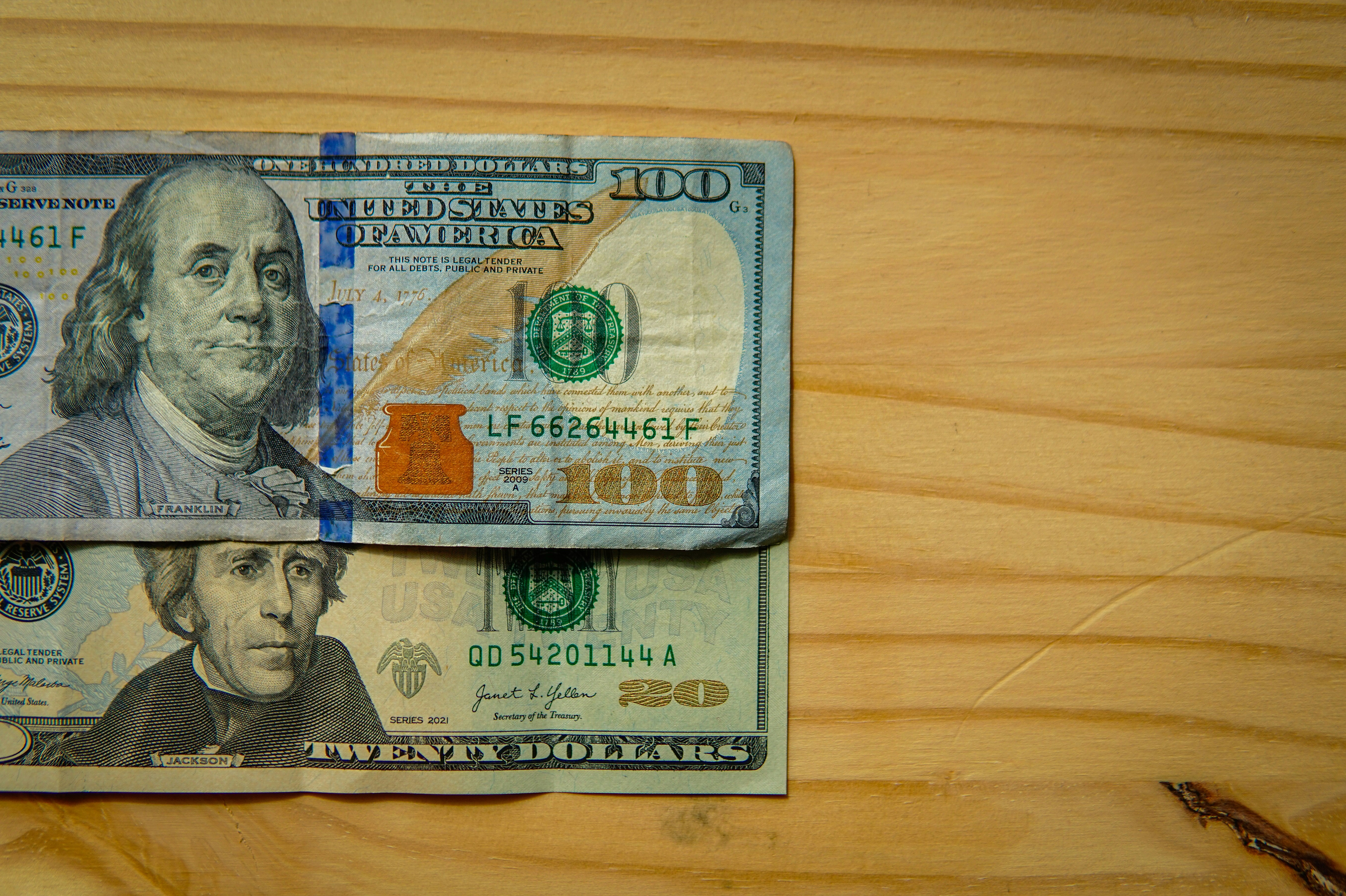 Illustrative photograph: Us dollar bills on a wooden surface
