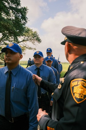 A police officer inspecting cadets in uniform, illustrating the law enforcement career path taught at Basic Academy in Henderson
