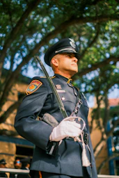 Police officer in dress uniform holding a ceremonial sword.