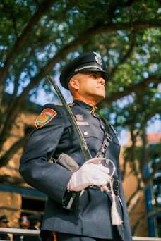 Police officer in dress uniform holding a ceremonial sword.