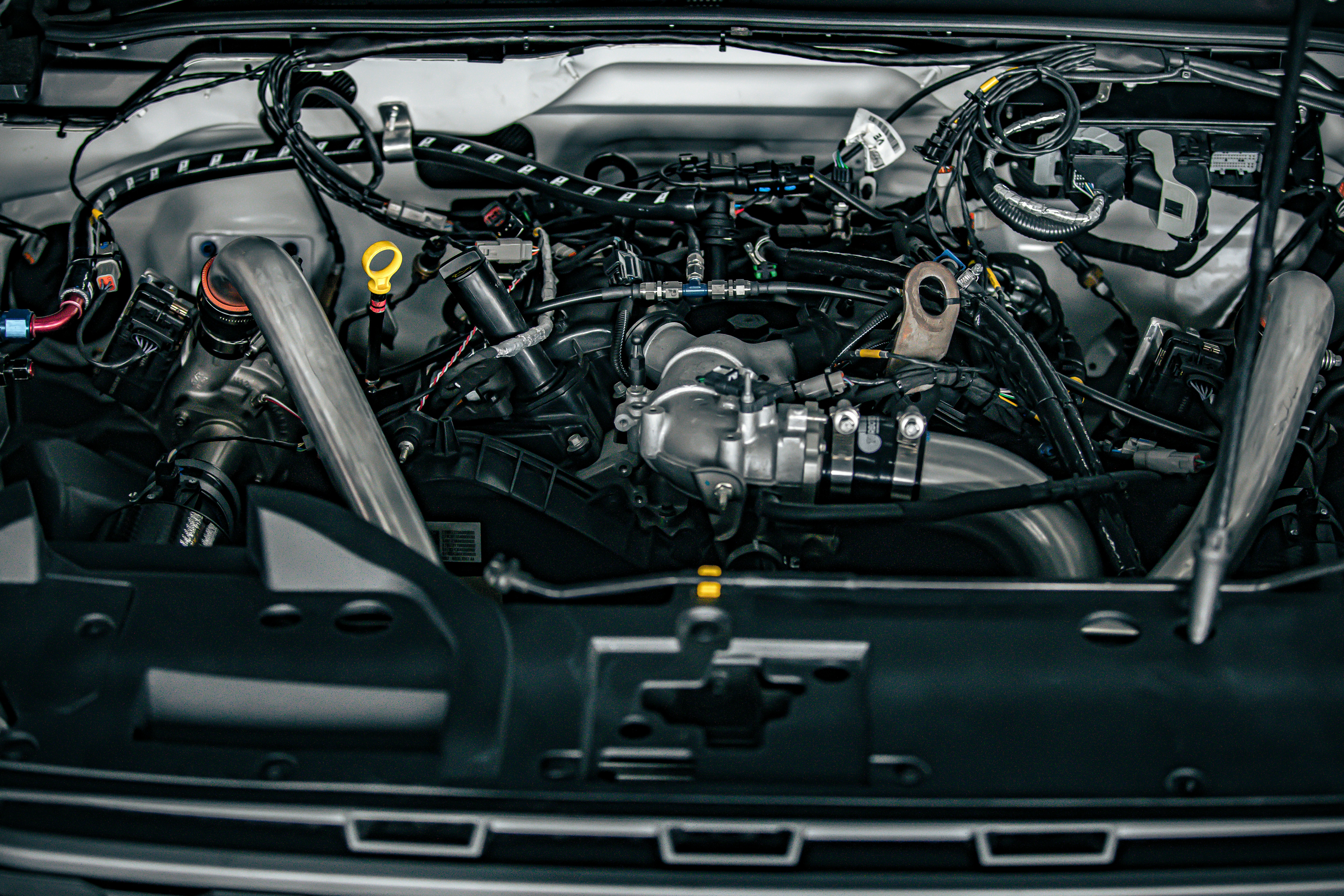 Engine bay diagram highlighting car AC system components under the hood