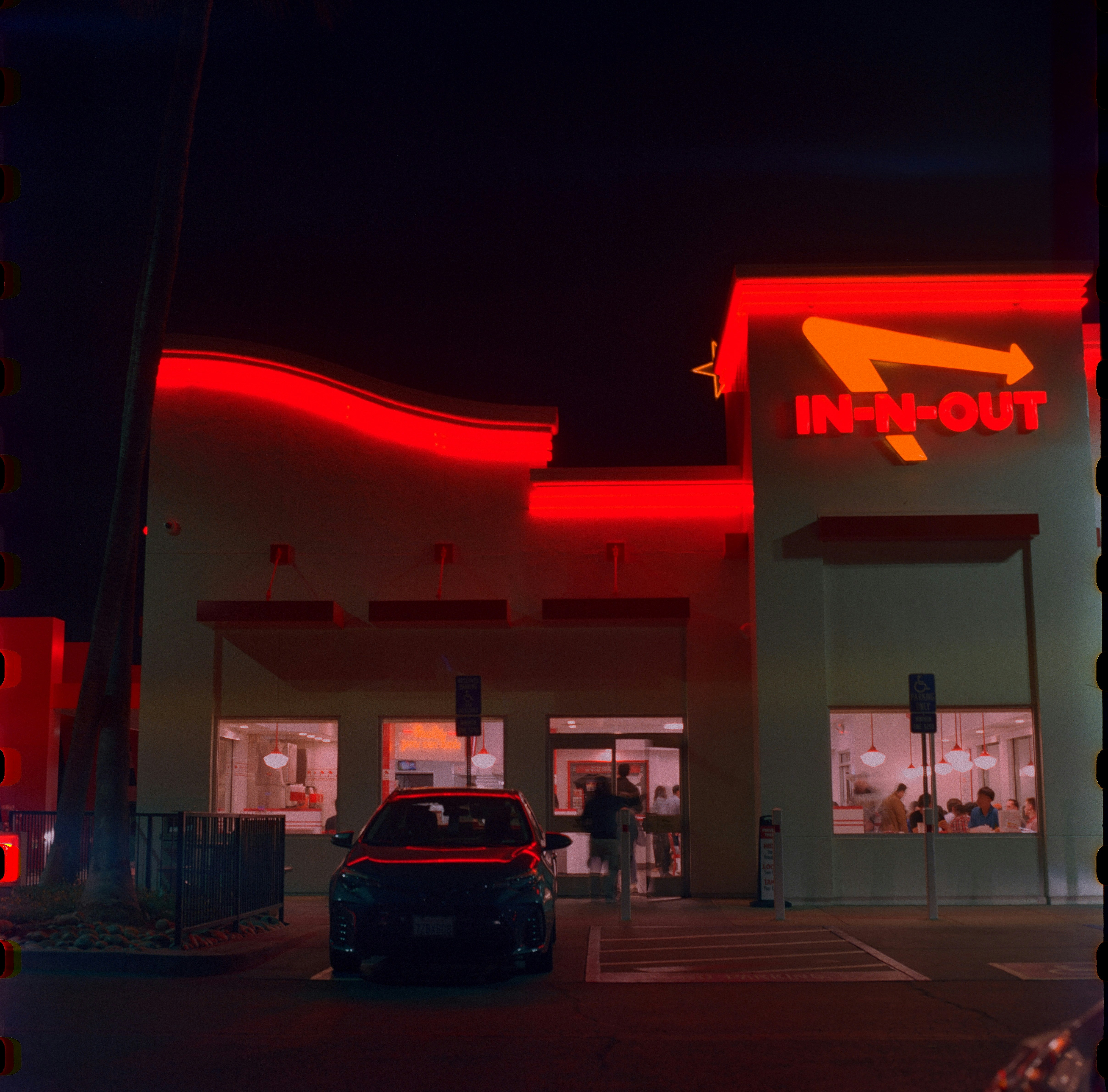 In-n-out burger restaurant illuminated by red neon lights at night