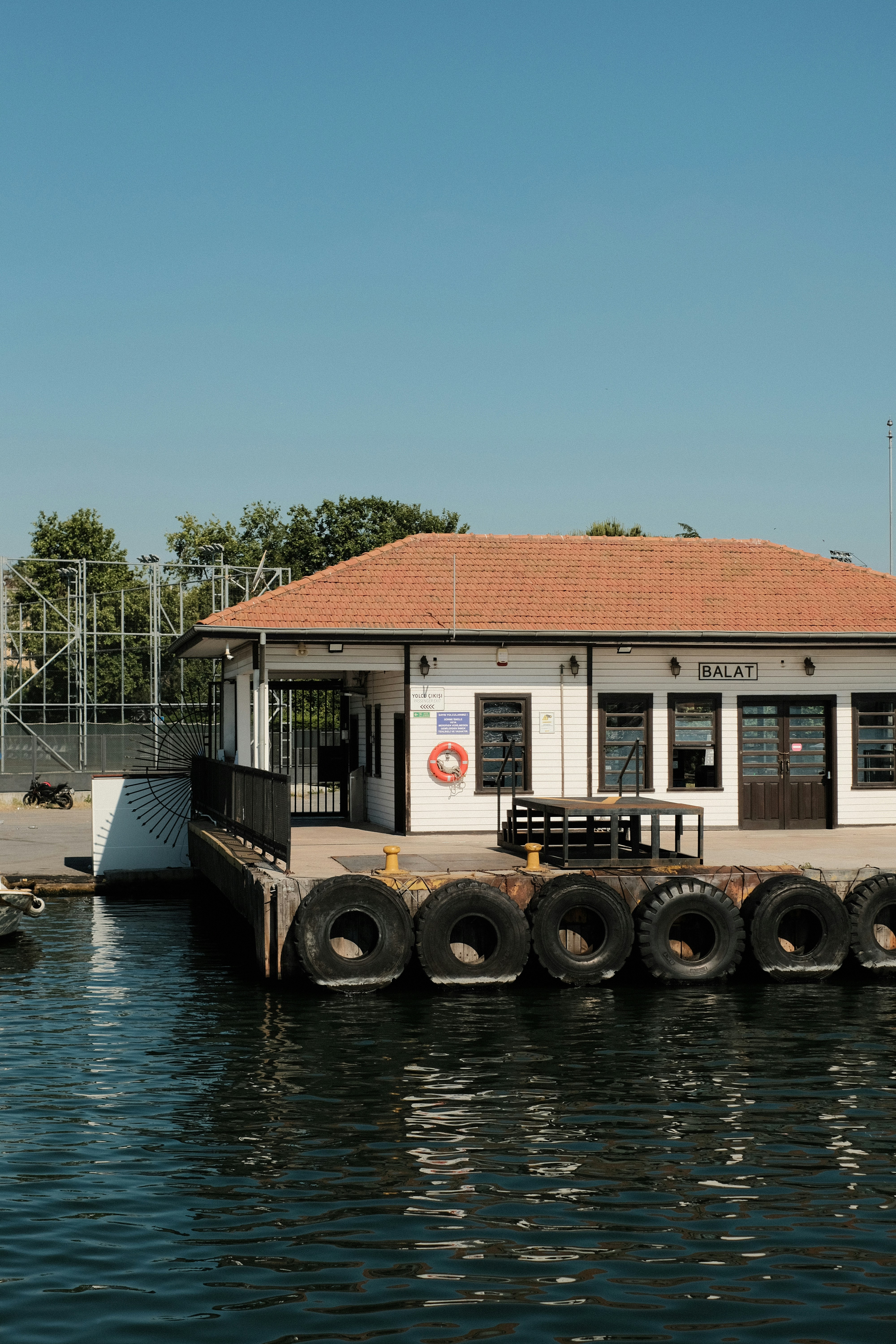 White building with red roof at a sunny pier