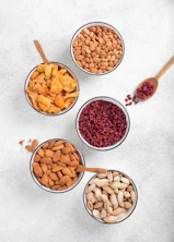 Bowls of almonds, pistachios, dried apricots, and cranberries