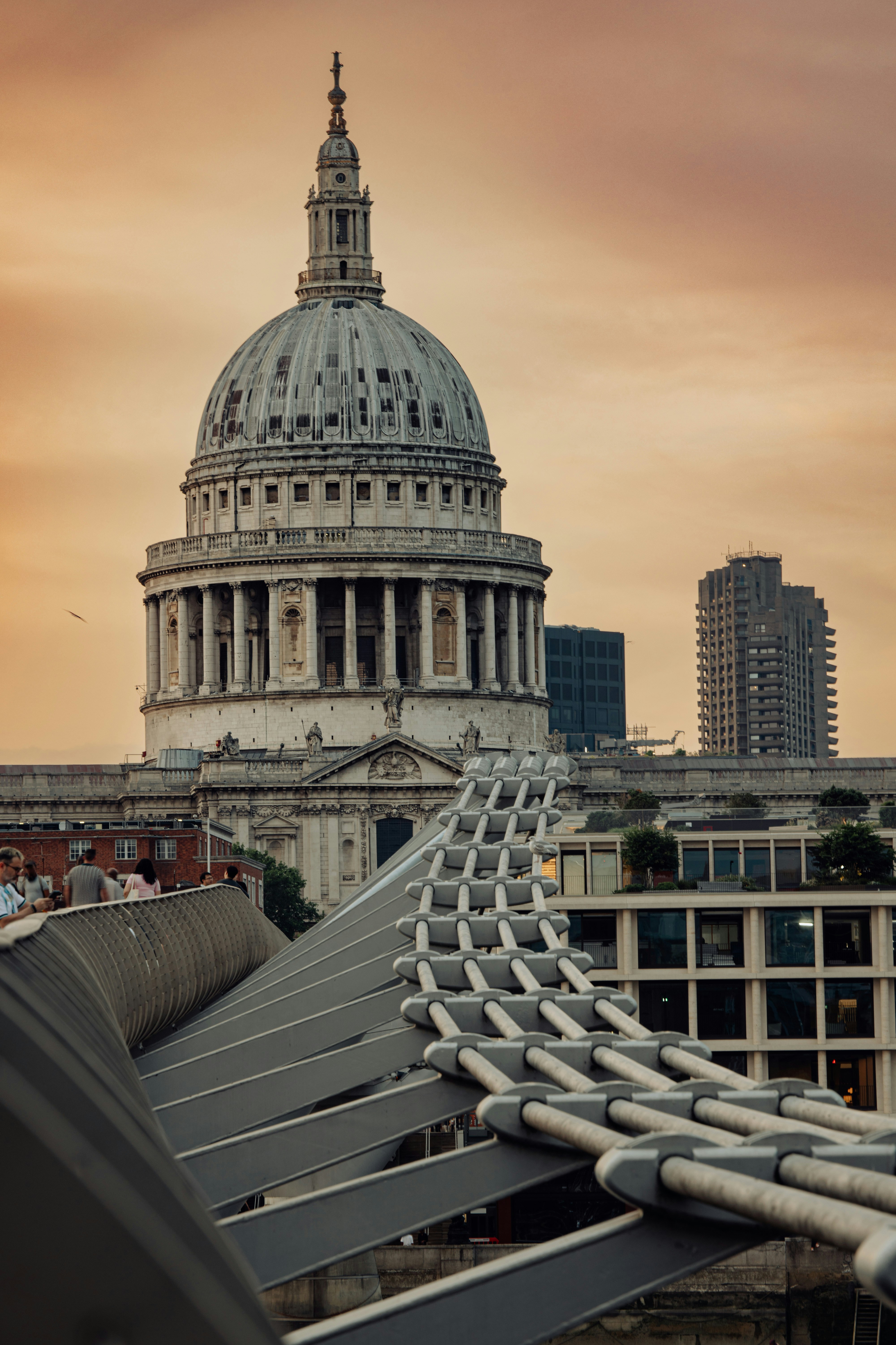 Iconic st. paul's cathedral and millennium bridge under orange sky