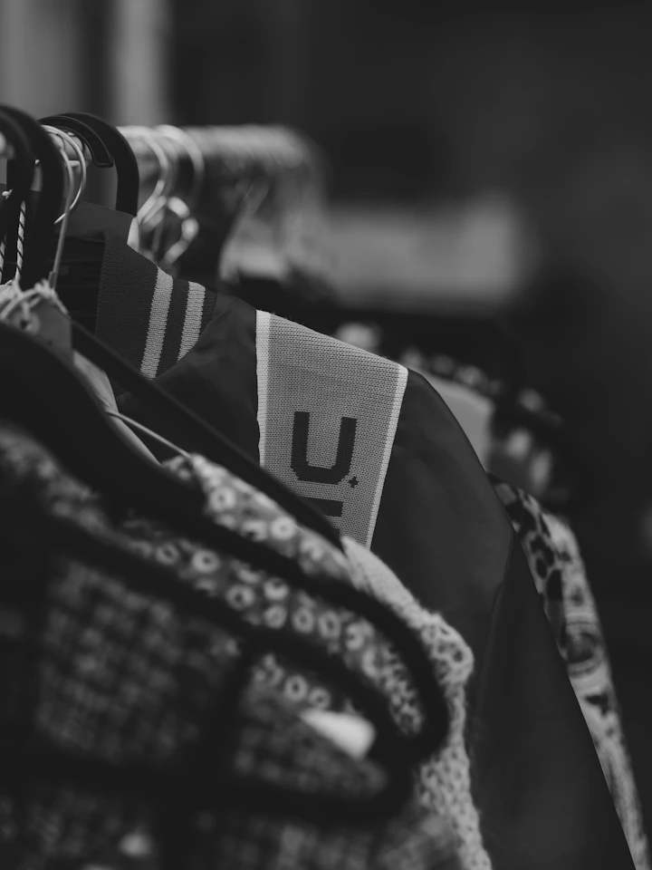 Clothes with a "u." logo hanging on a rack