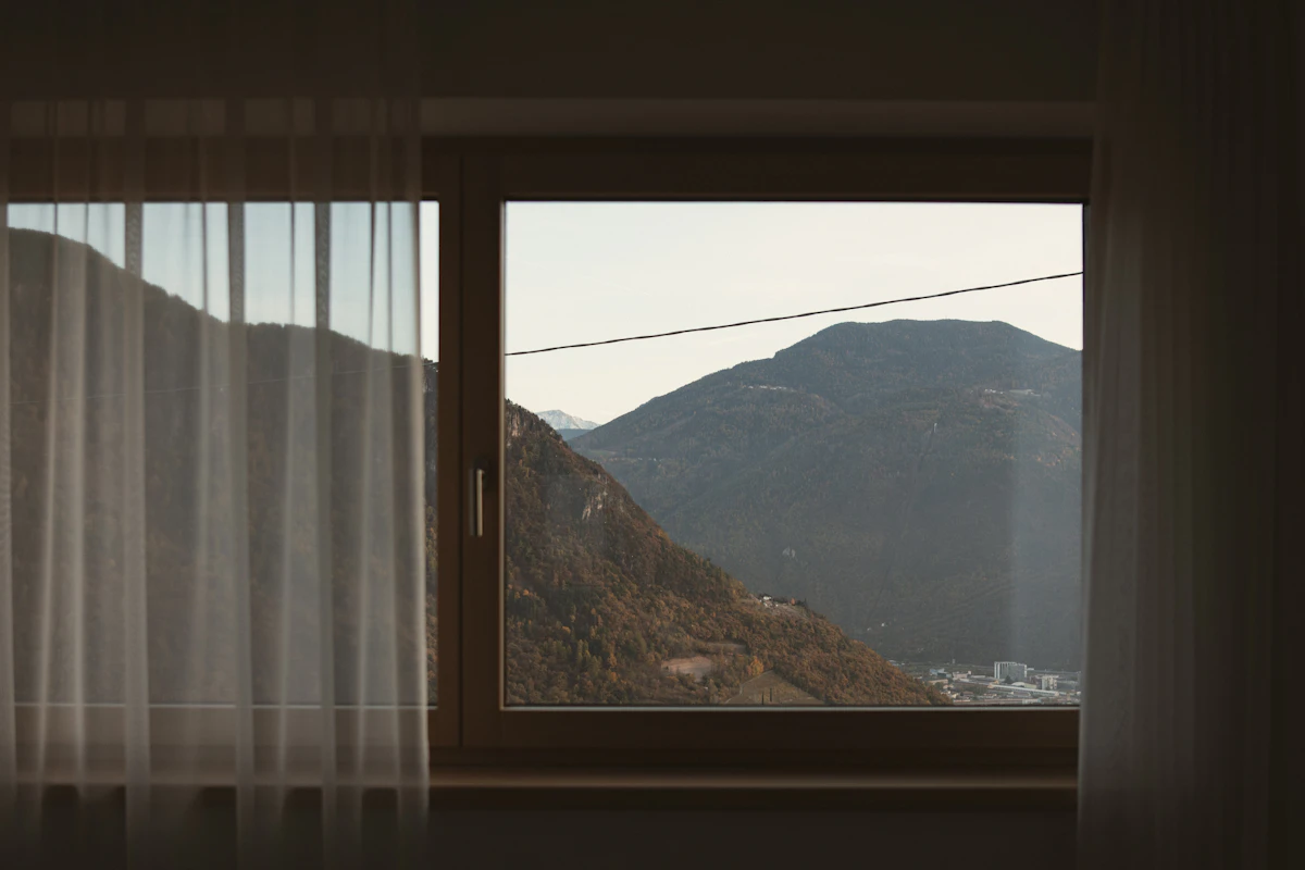 Habitación con una gran ventana abierta a las montañas