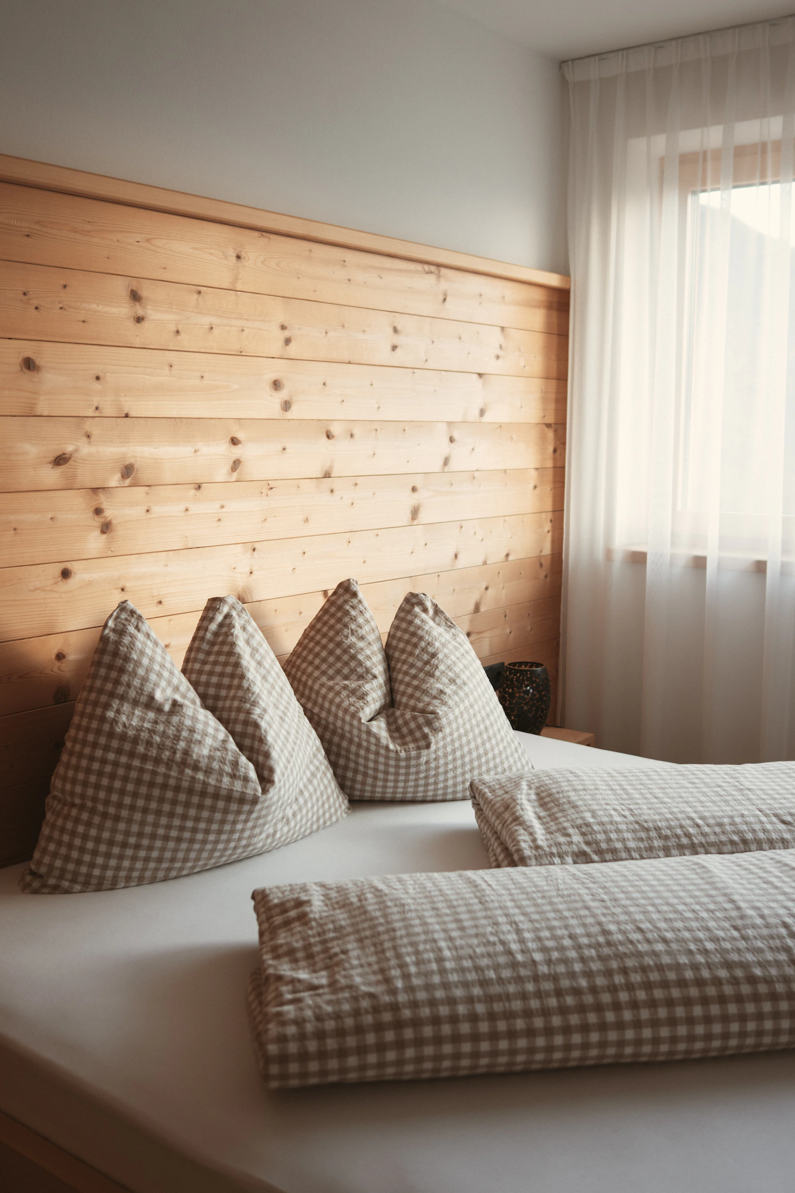Cozy bedroom with natural wood headboard and layered bedding