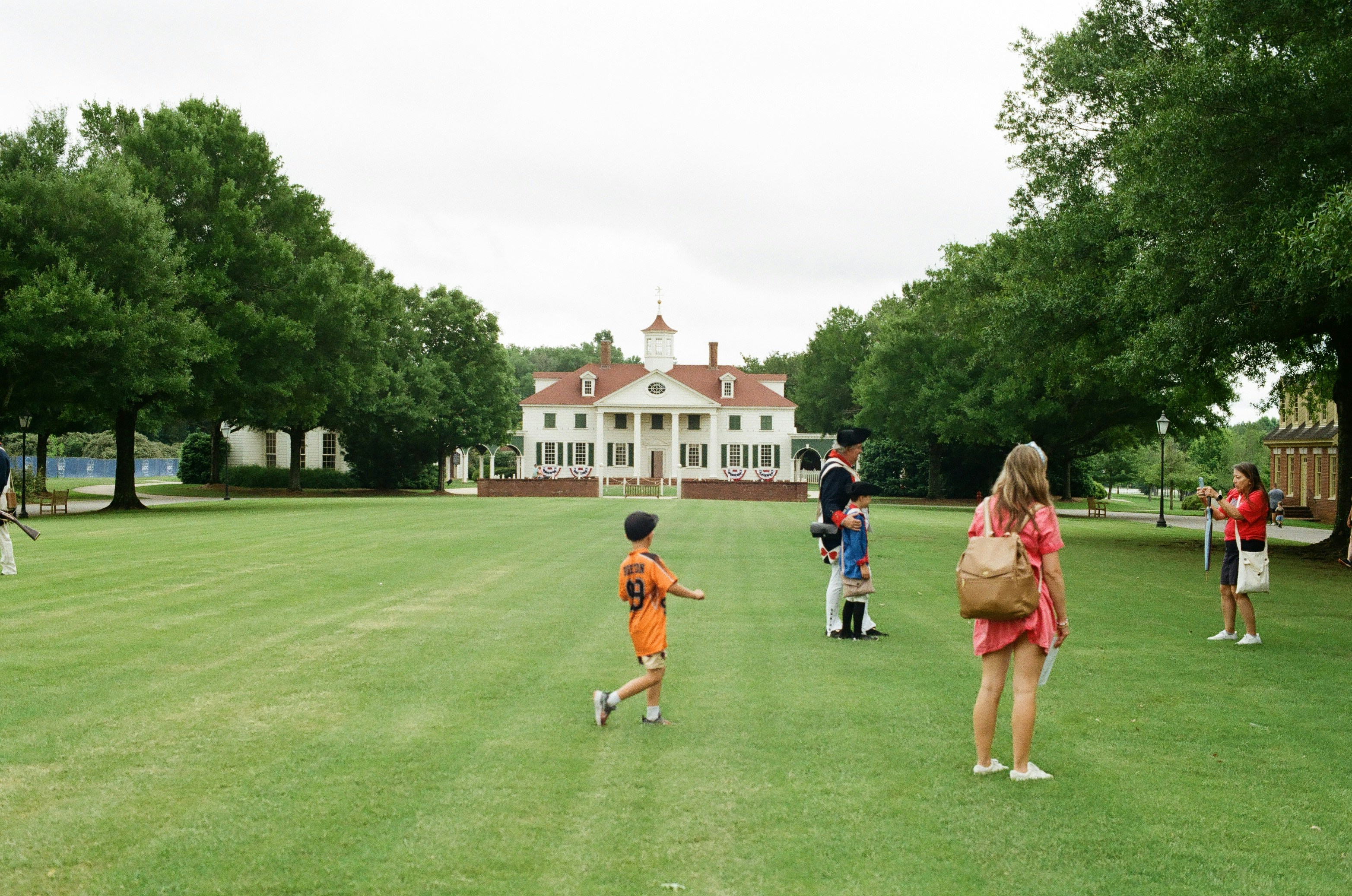 Historic mansion with people on a large green lawn - historic sites near me