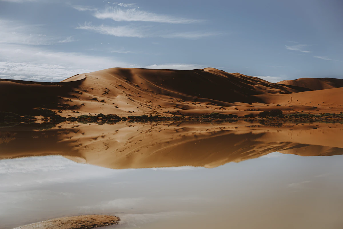 Sand dunes reflecting in calm lagoon water