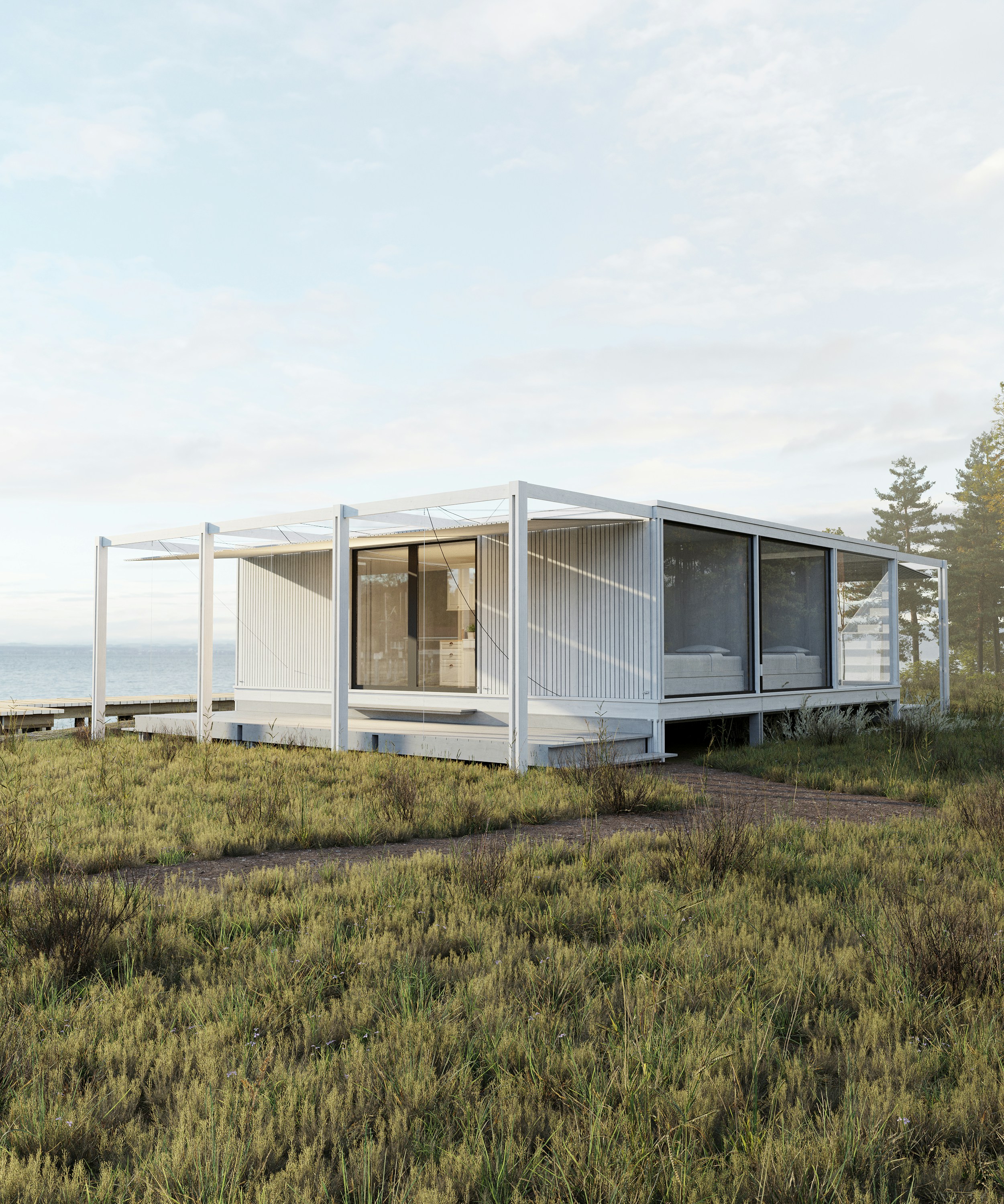 Modern white house with large windows overlooking the ocean.