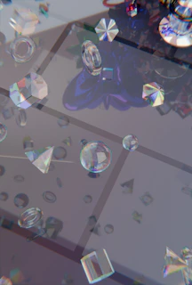 Transparent faceted crystals and jewels scattered on a reflective surface