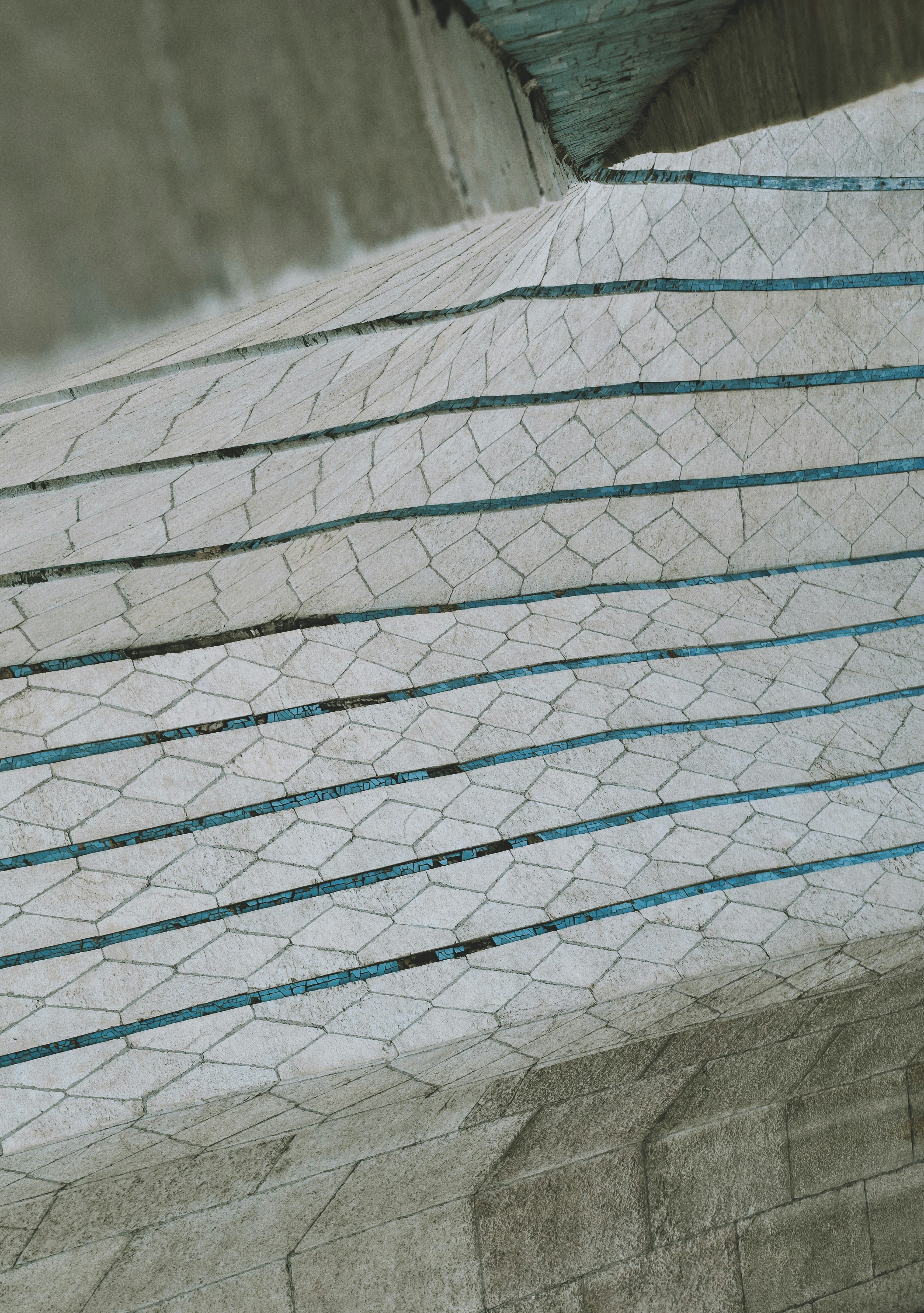 Surface en béton avec des lignes bleues et un motif en maille.