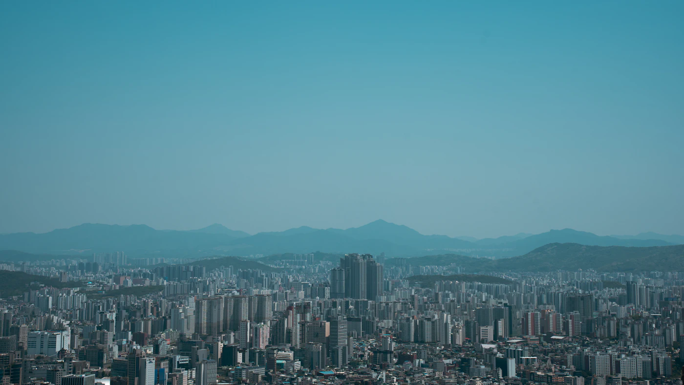 City buildings in front of mountains under a clear blue sky