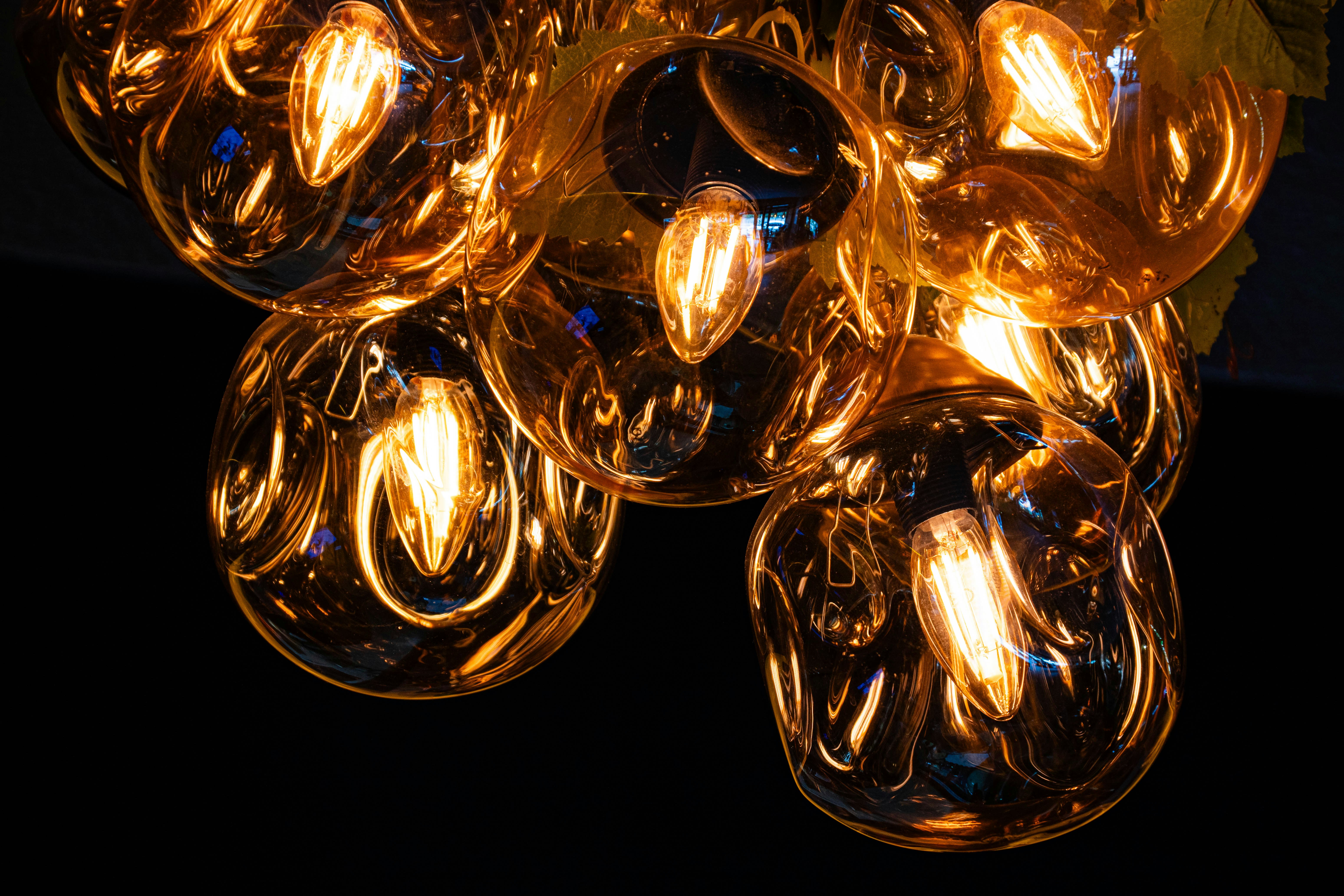 Múltiples bombillas ámbar brillantes sobre un fondo oscuro.