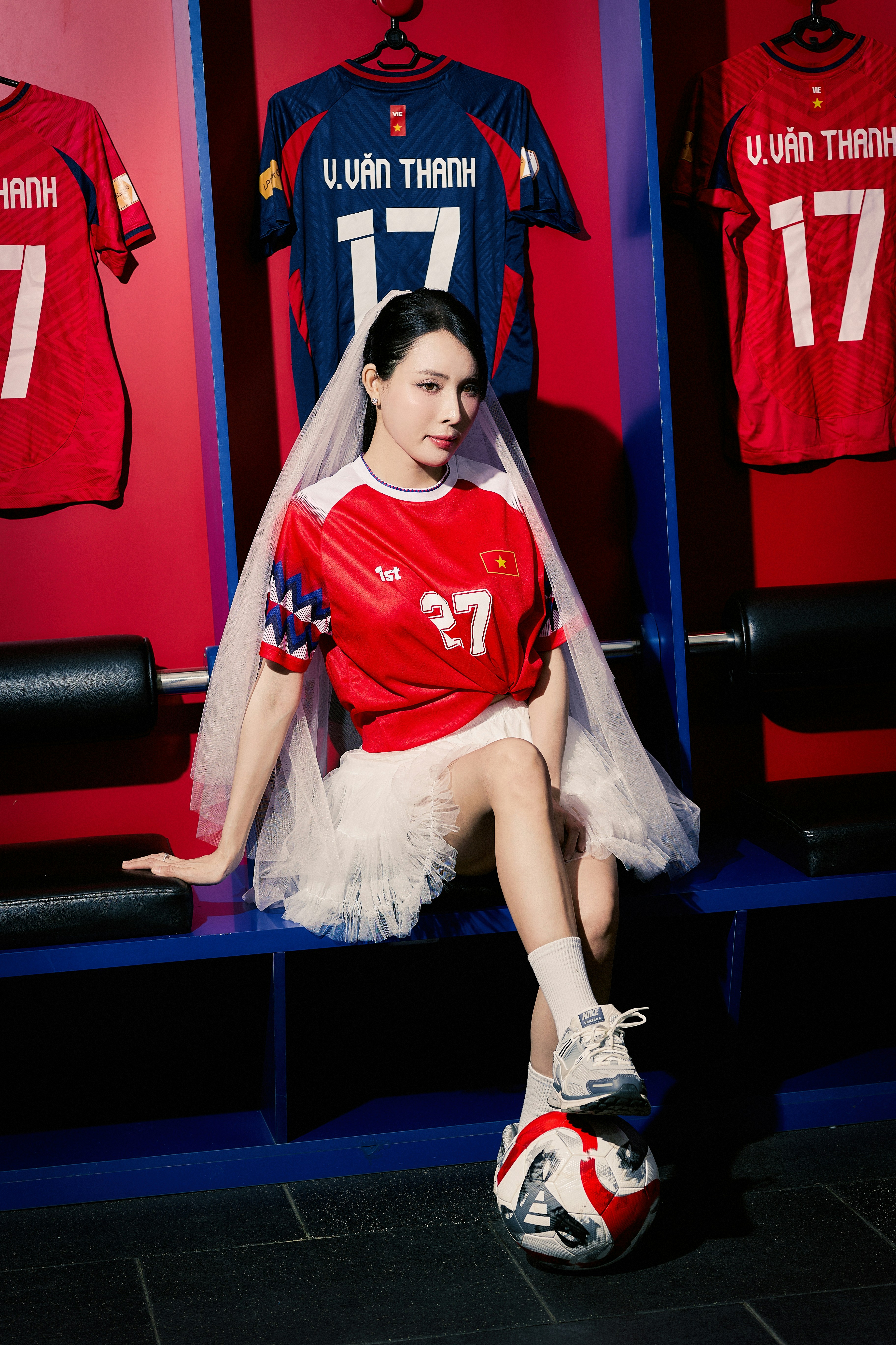 Woman wearing football jersey and veil with a soccer ball.