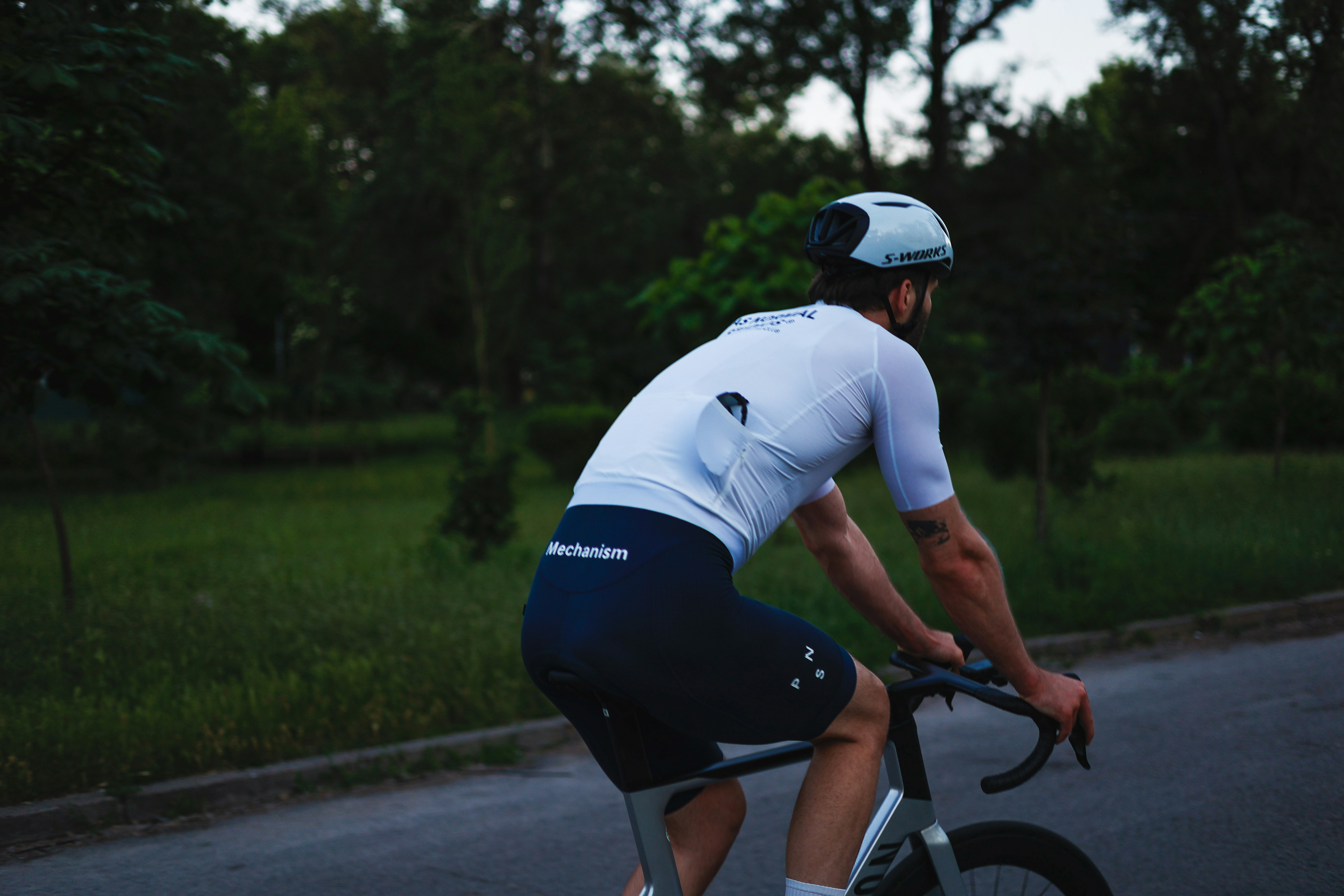 Cyclist in white jersey rides bike outdoors