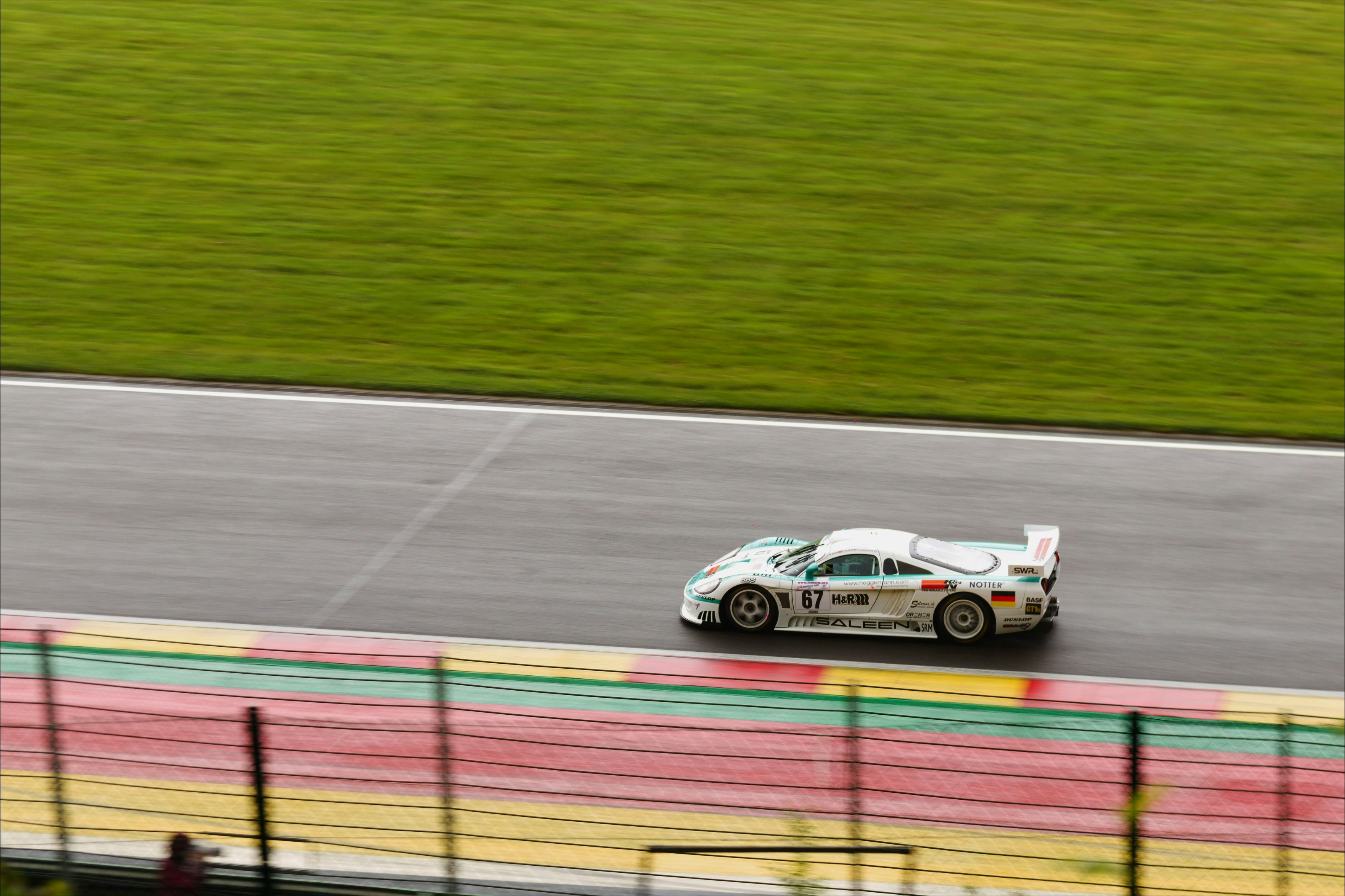 White race car speeds on a track