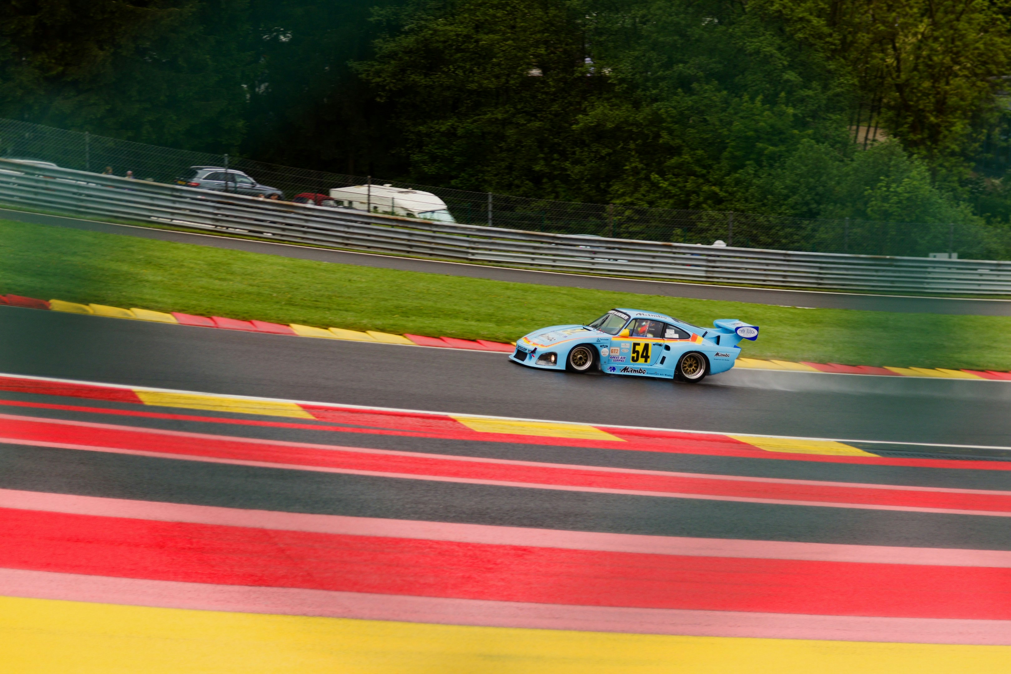 Light blue race car drives fast on a vibrant track