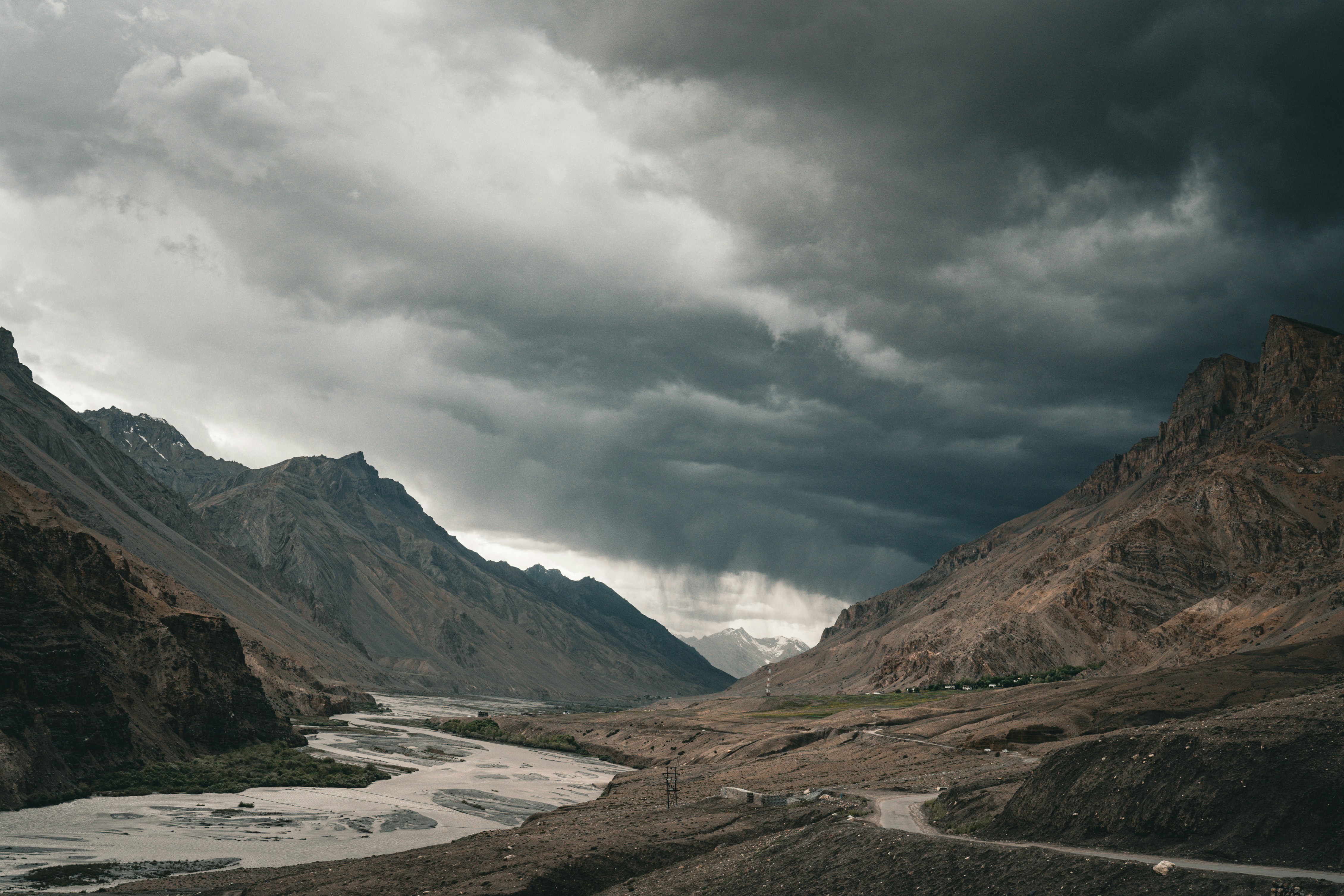 Dramatic clouds over a river winding through a mountain valley