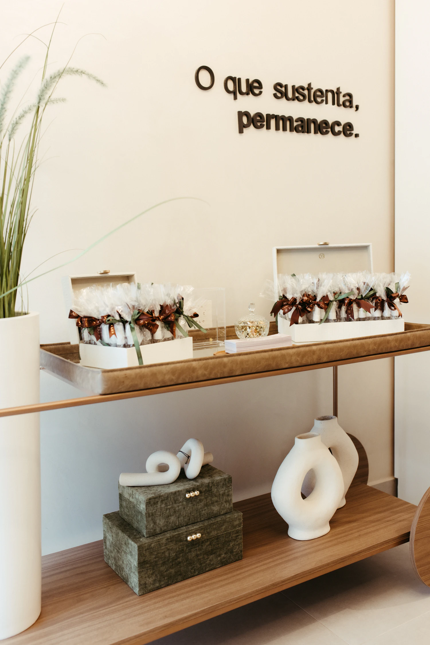 Minimal console arranged with gift boxes, ceramic vases, and party favors