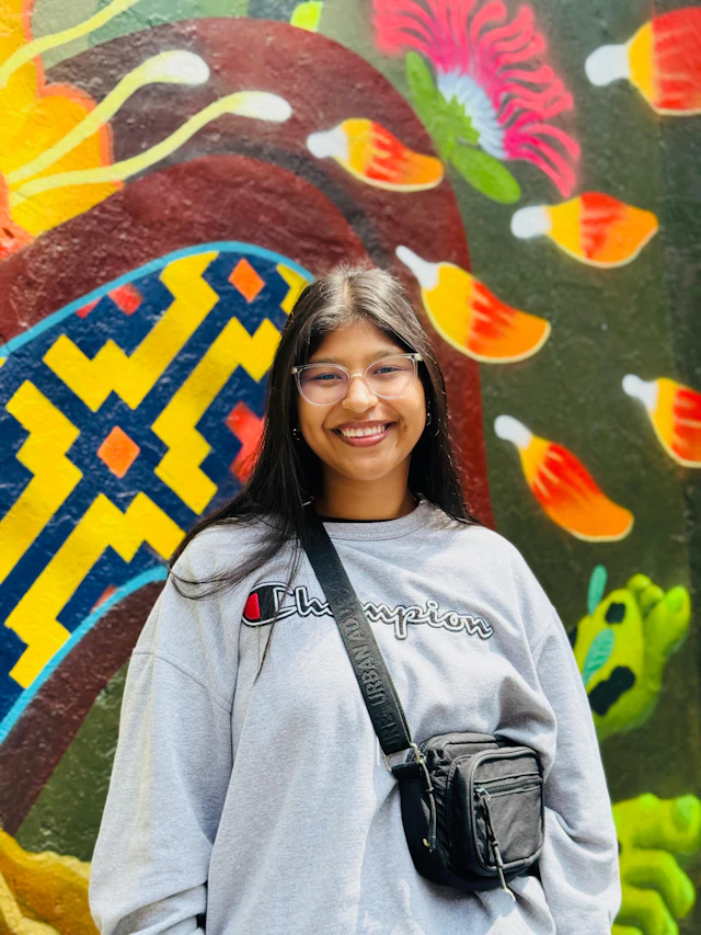 A person smiling at the camera in natural light.