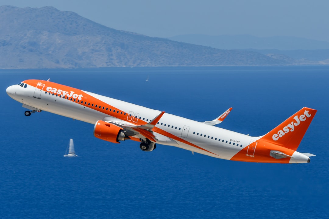 An easyjet airplane takes off over the blue sea.