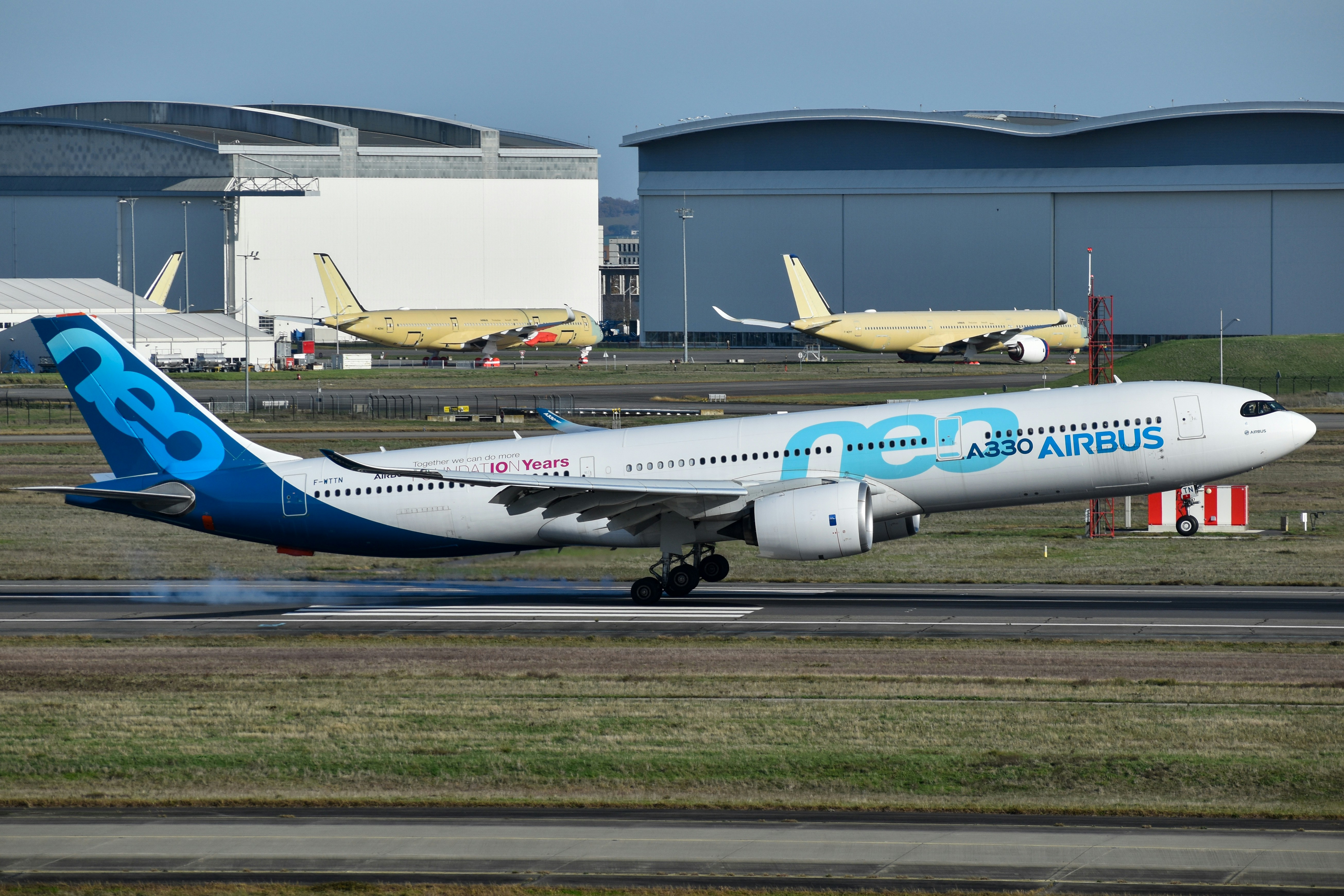 White airbus neo airplane taking off from a runway.