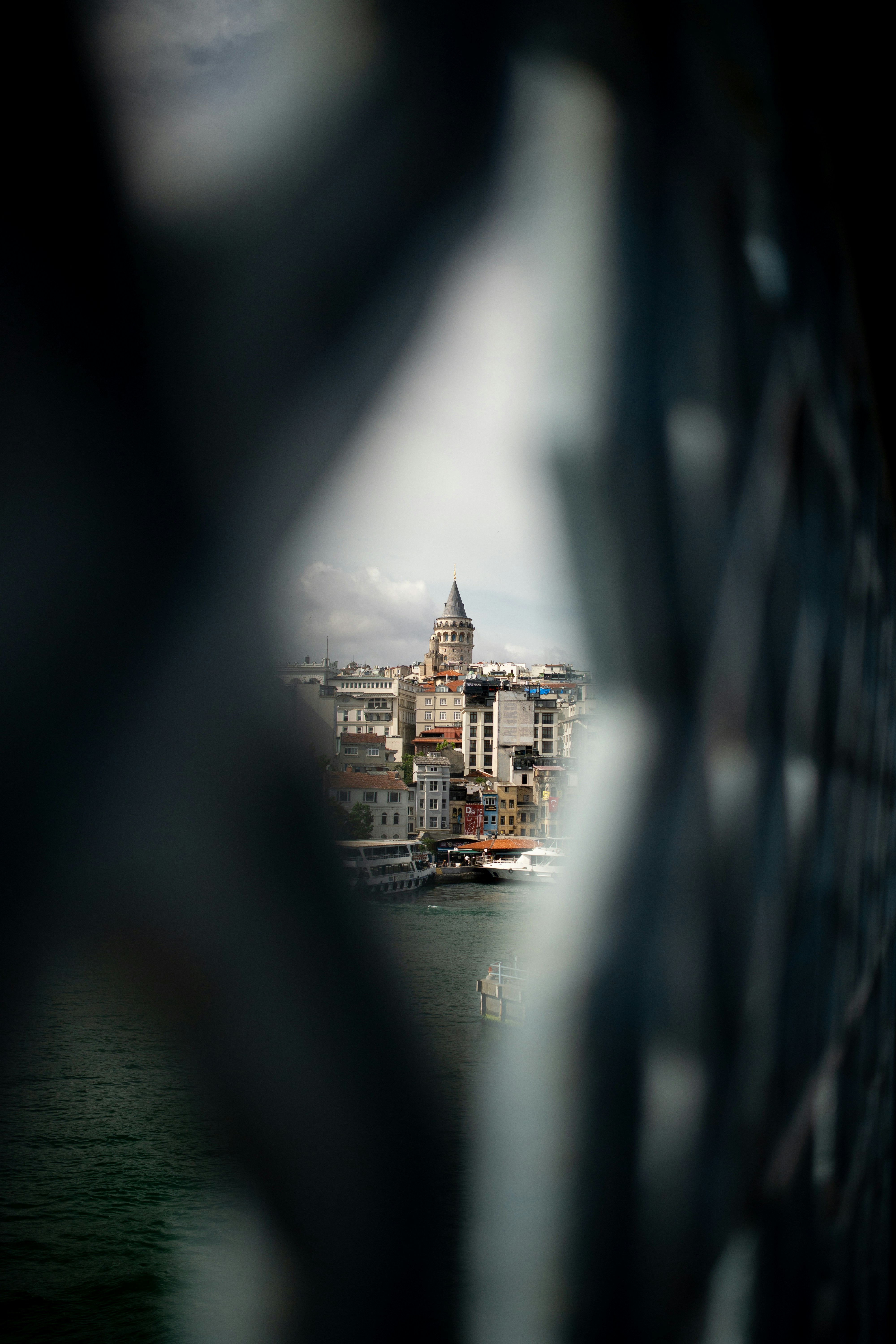 Istanbul's galata tower and cityscape glimpsed through a fence