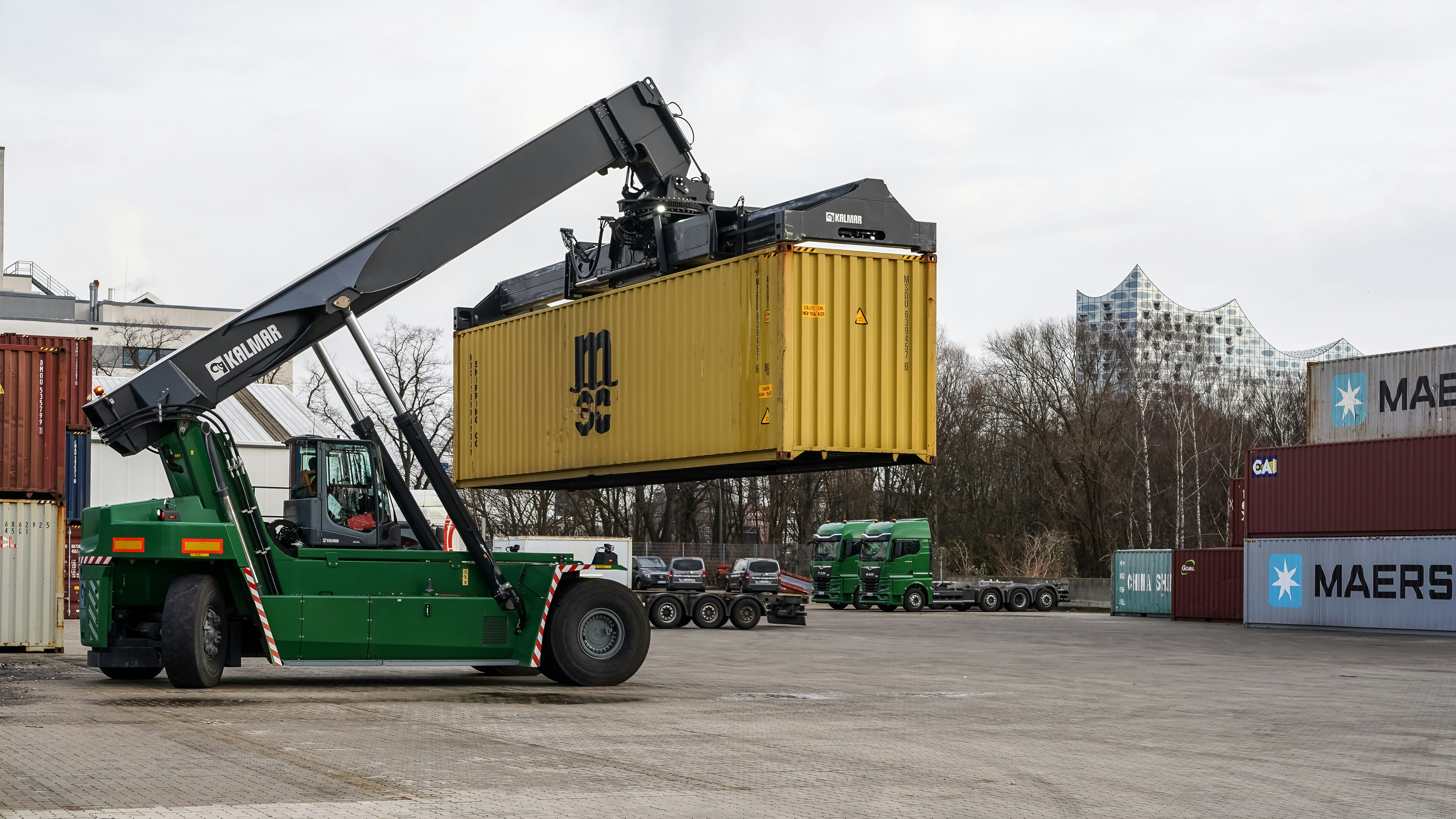 삼성·SK 반도체 계약학과와 삼성전자 헬스케어 확장 동향 - A green reach stacker lifting a yellow shipping container.