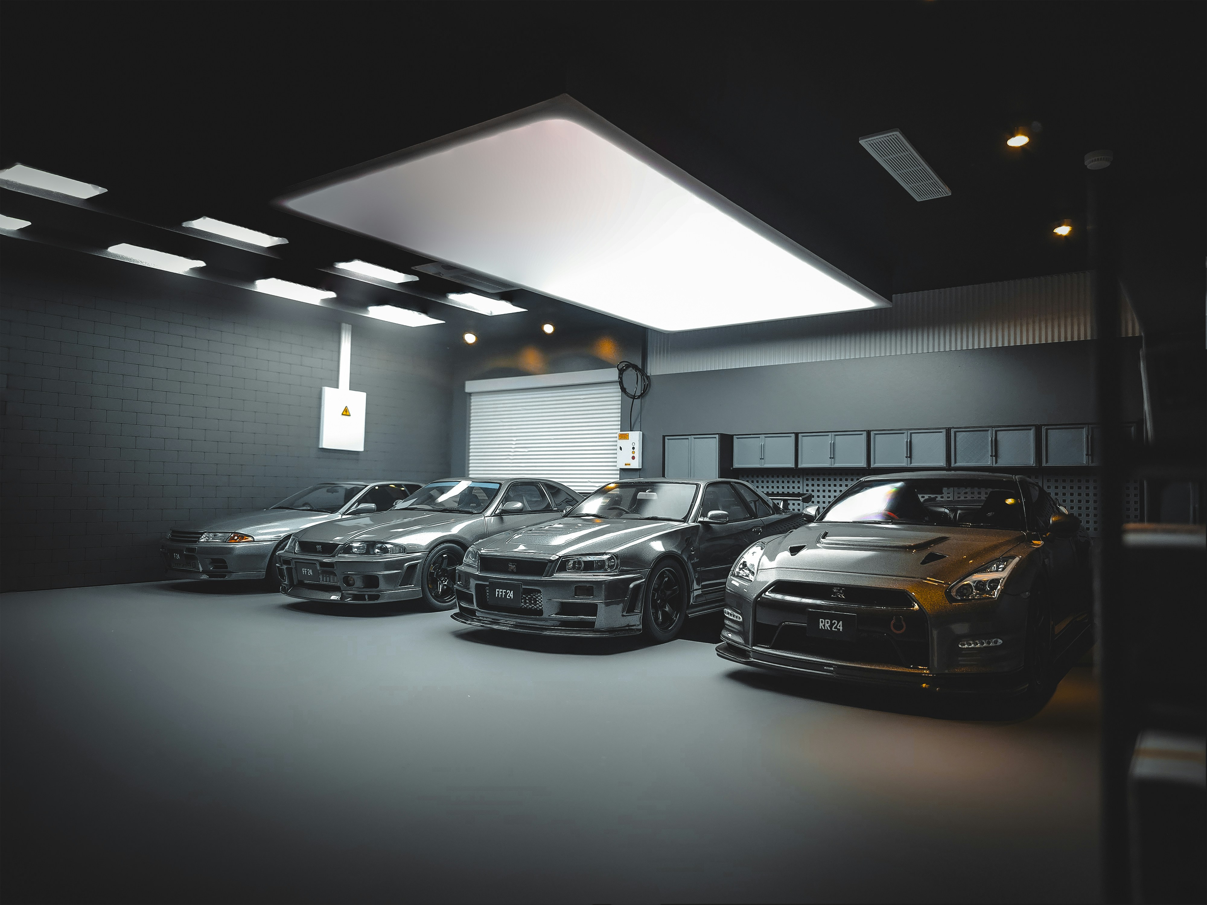 Several silver sports cars parked in a modern, well-lit garage