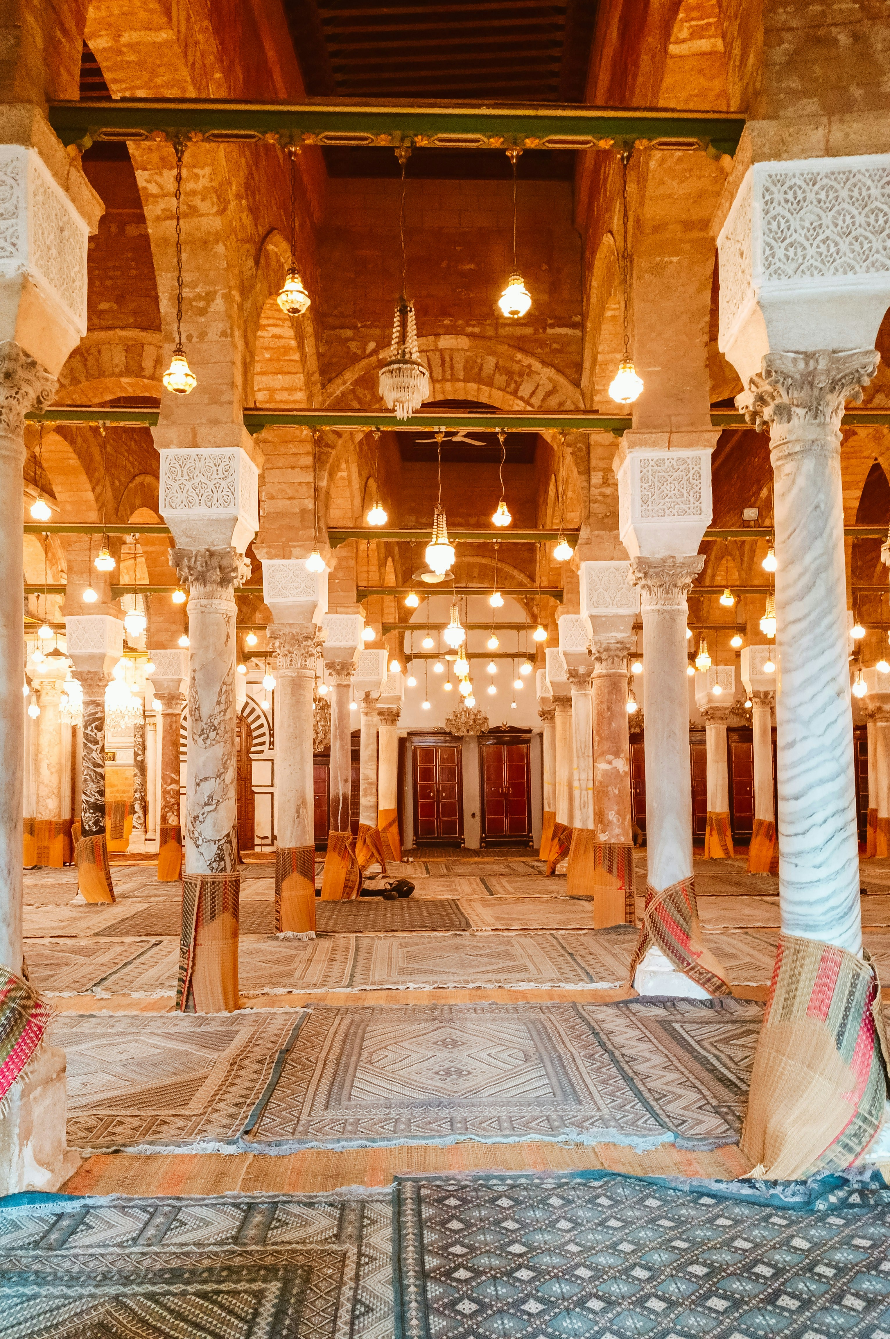 Verziertes Moschee-Inneres mit zahlreichen Säulen, Bögen und gemustertem Boden.