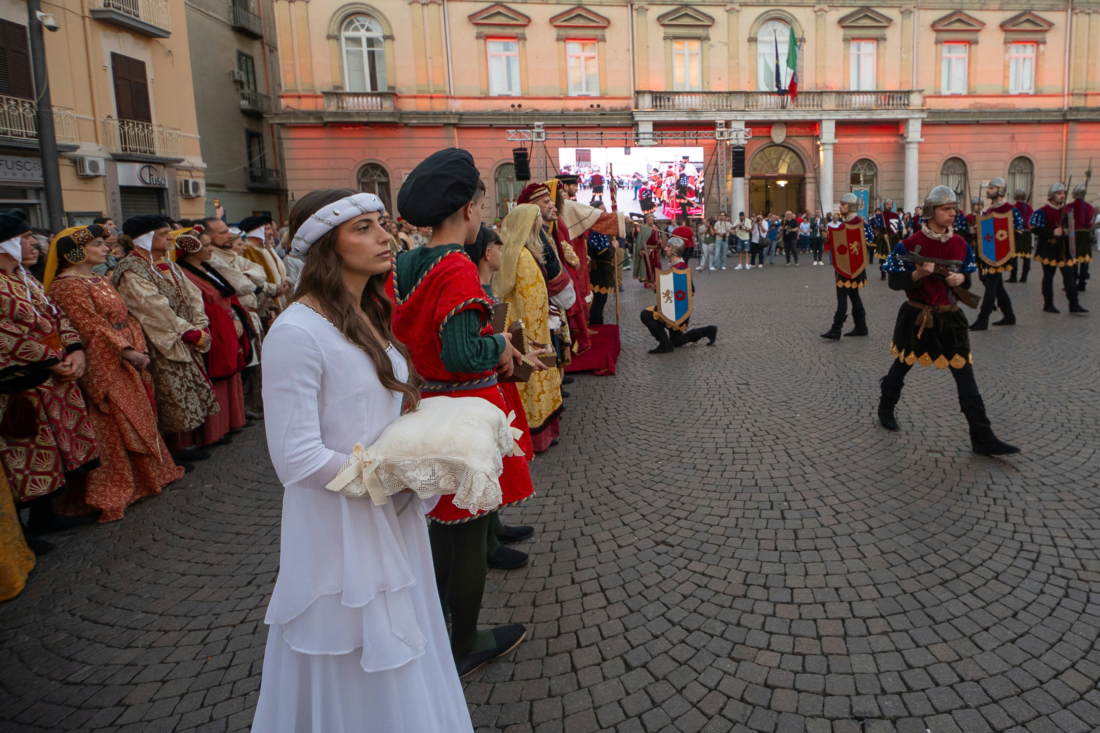 Menschen in mittelalterlichen Kostümen versammelten sich auf einem historischen Marktplatz.