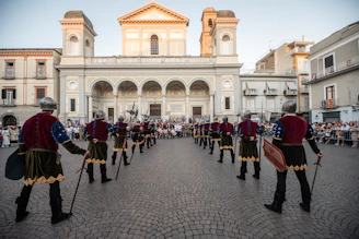 Costumed figures in a town square with a large church.