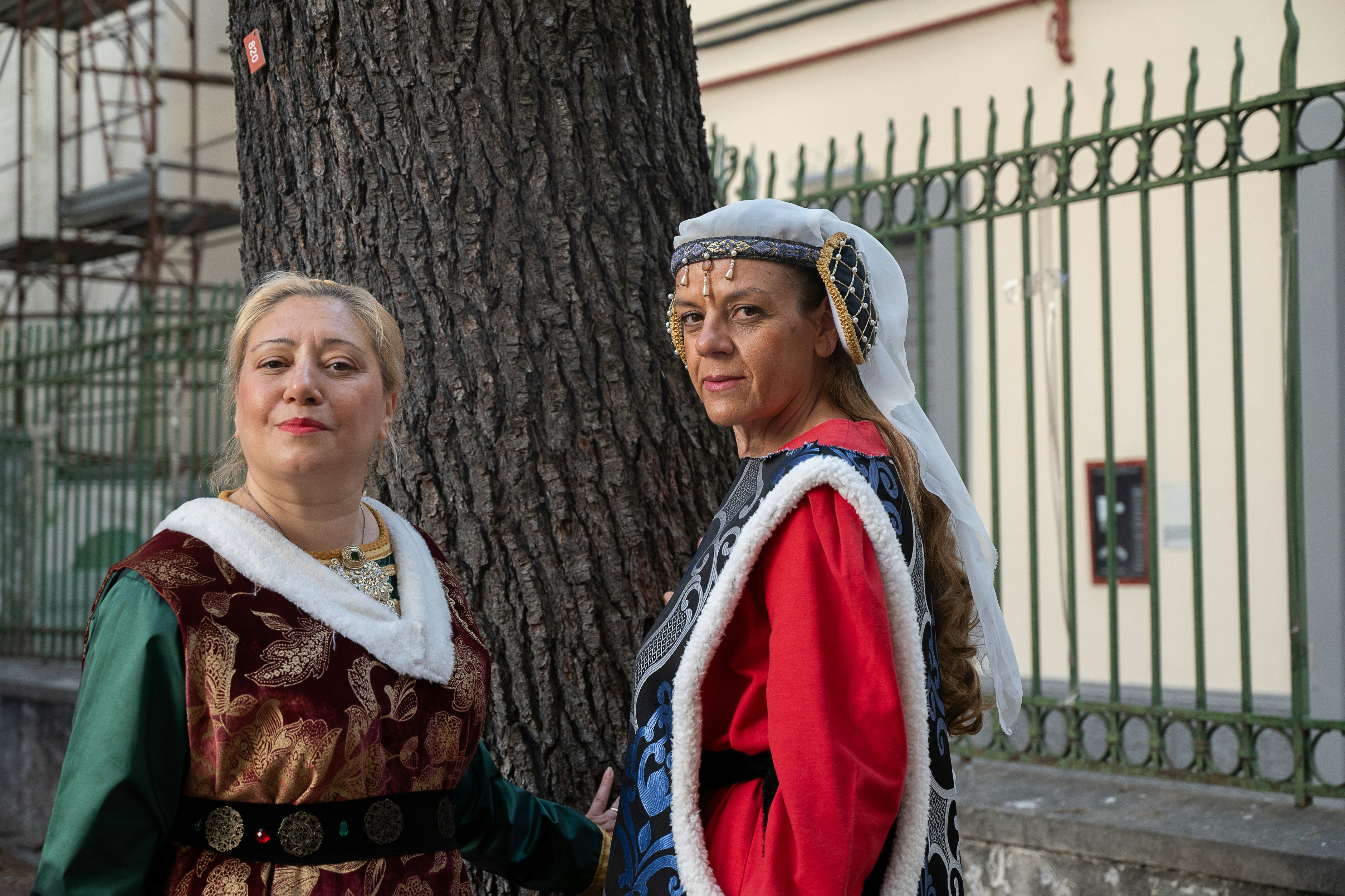 Zwei Frauen in historischen Kostümen stehen an einem Baum.