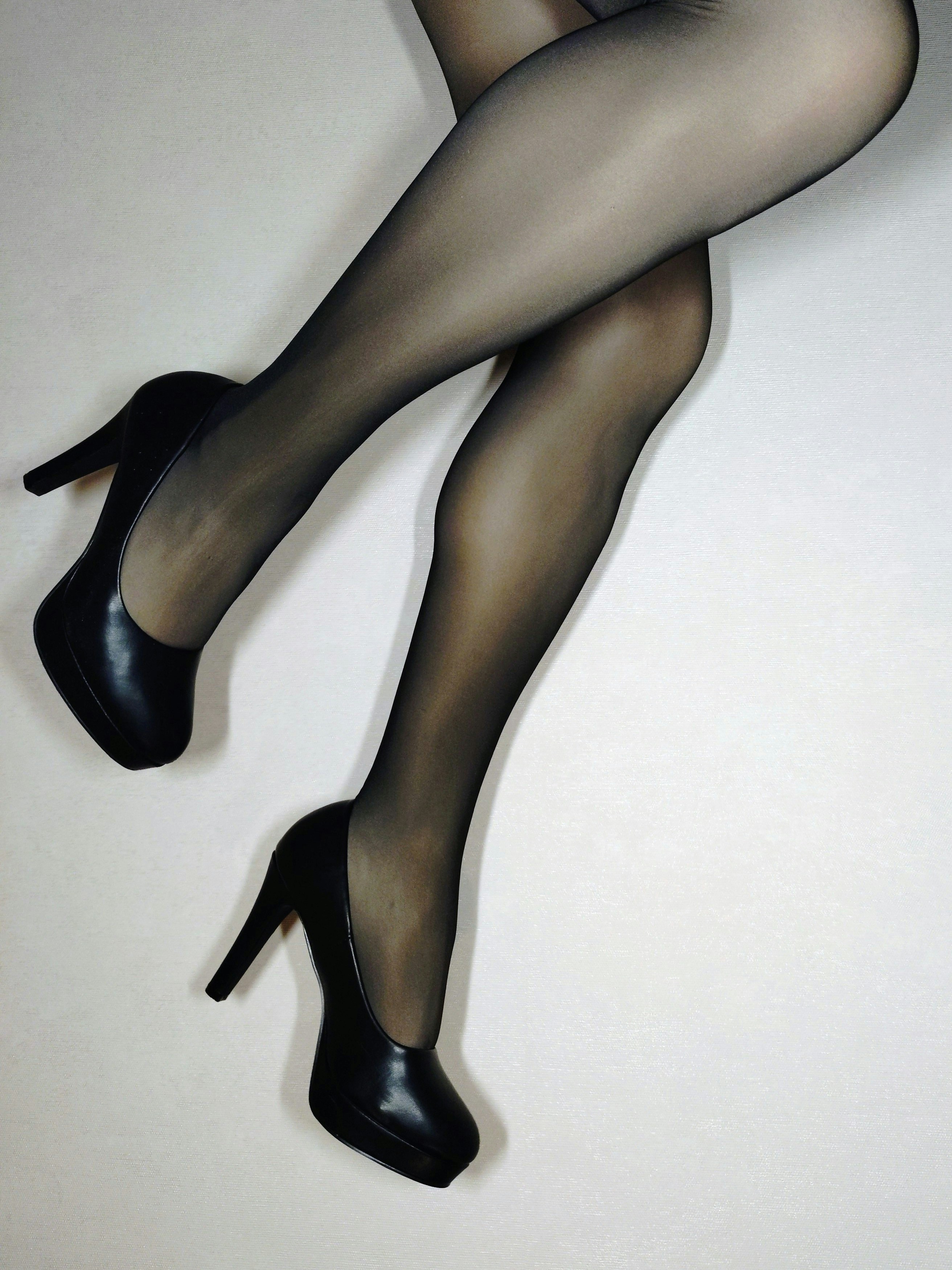 Woman's legs in black sheer stockings and high heels.