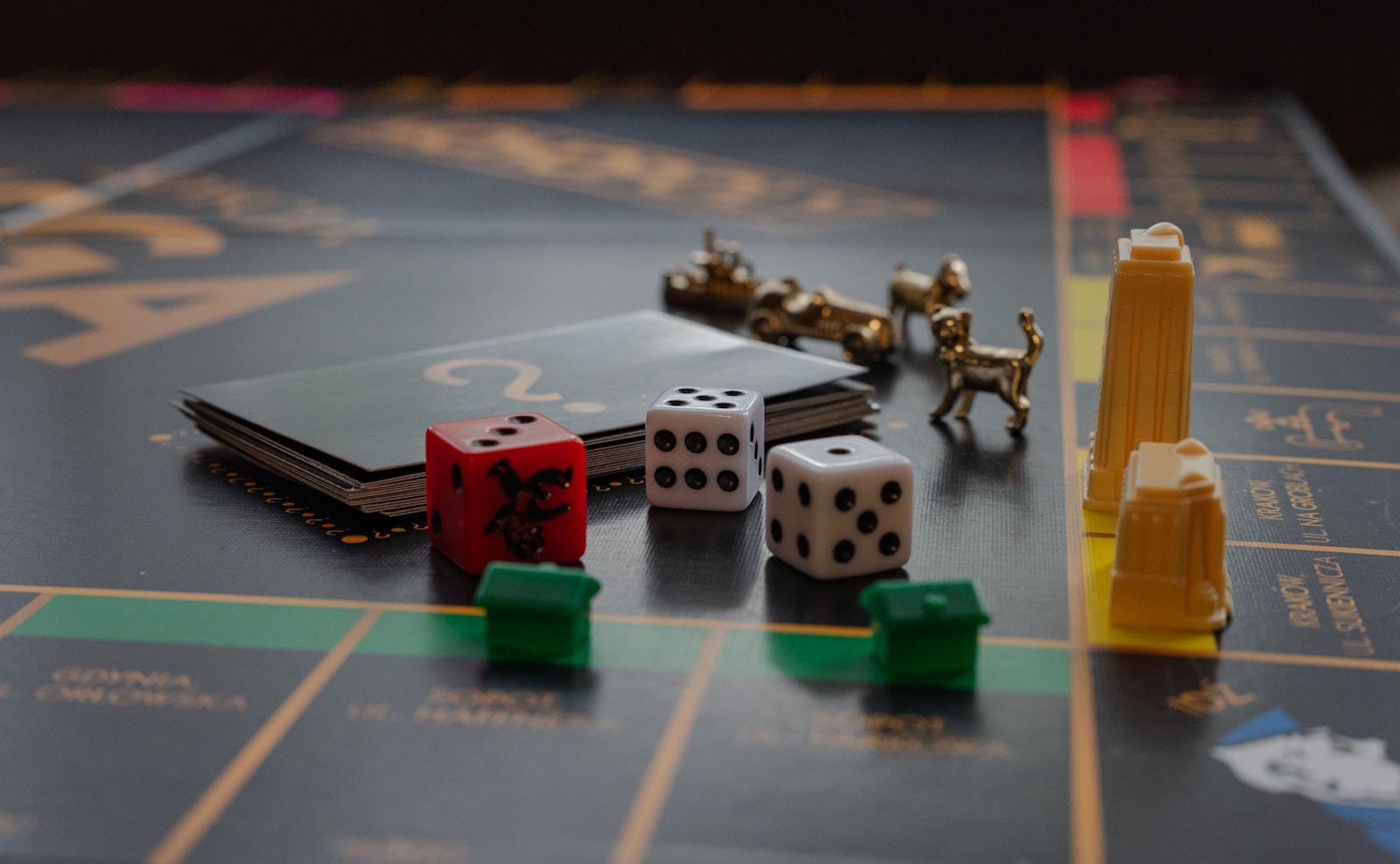 Würfel, Spielfiguren und kleine Monopoly-Häuser