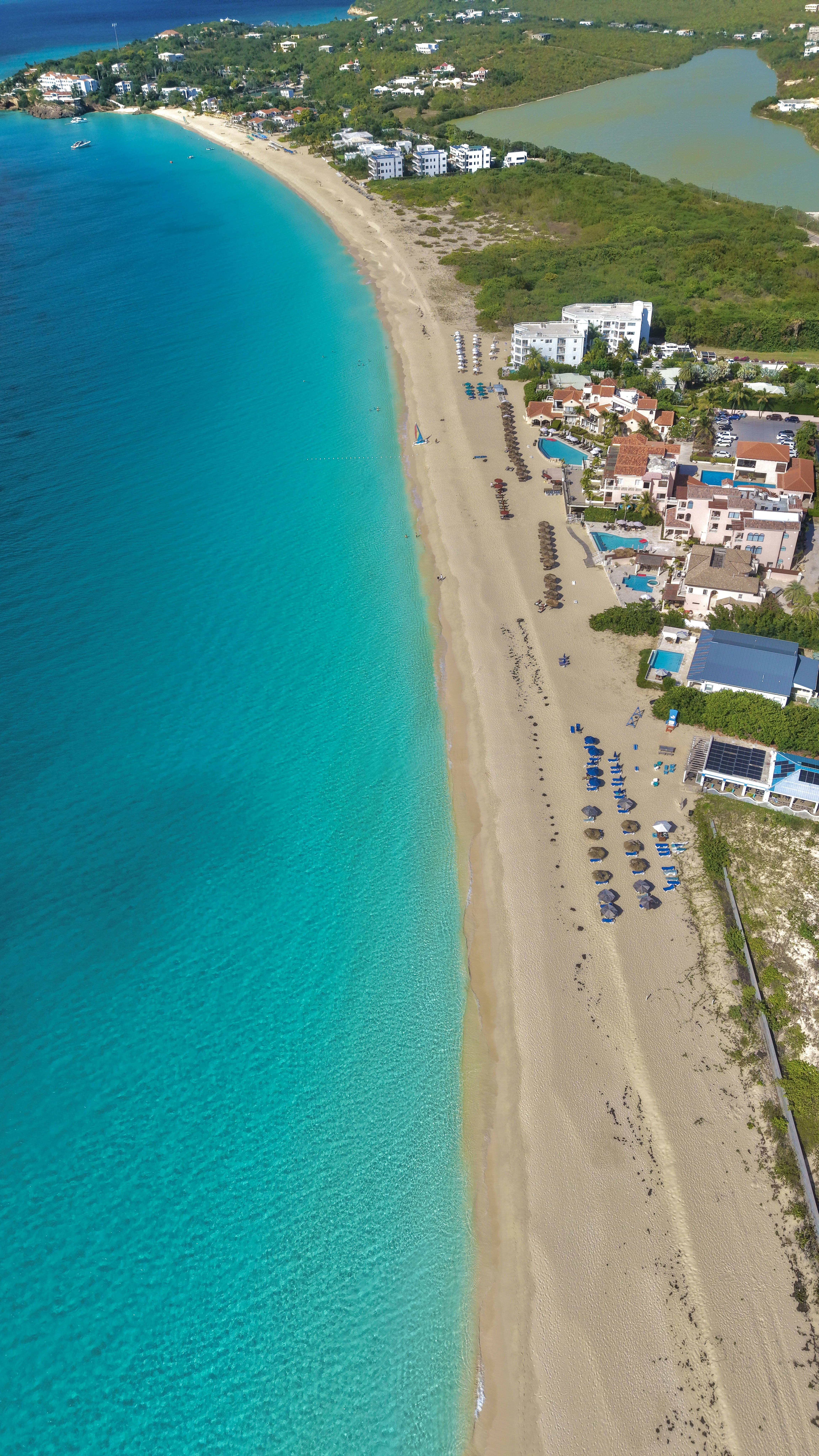 Long sandy beach with turquoise ocean and coastal resorts.