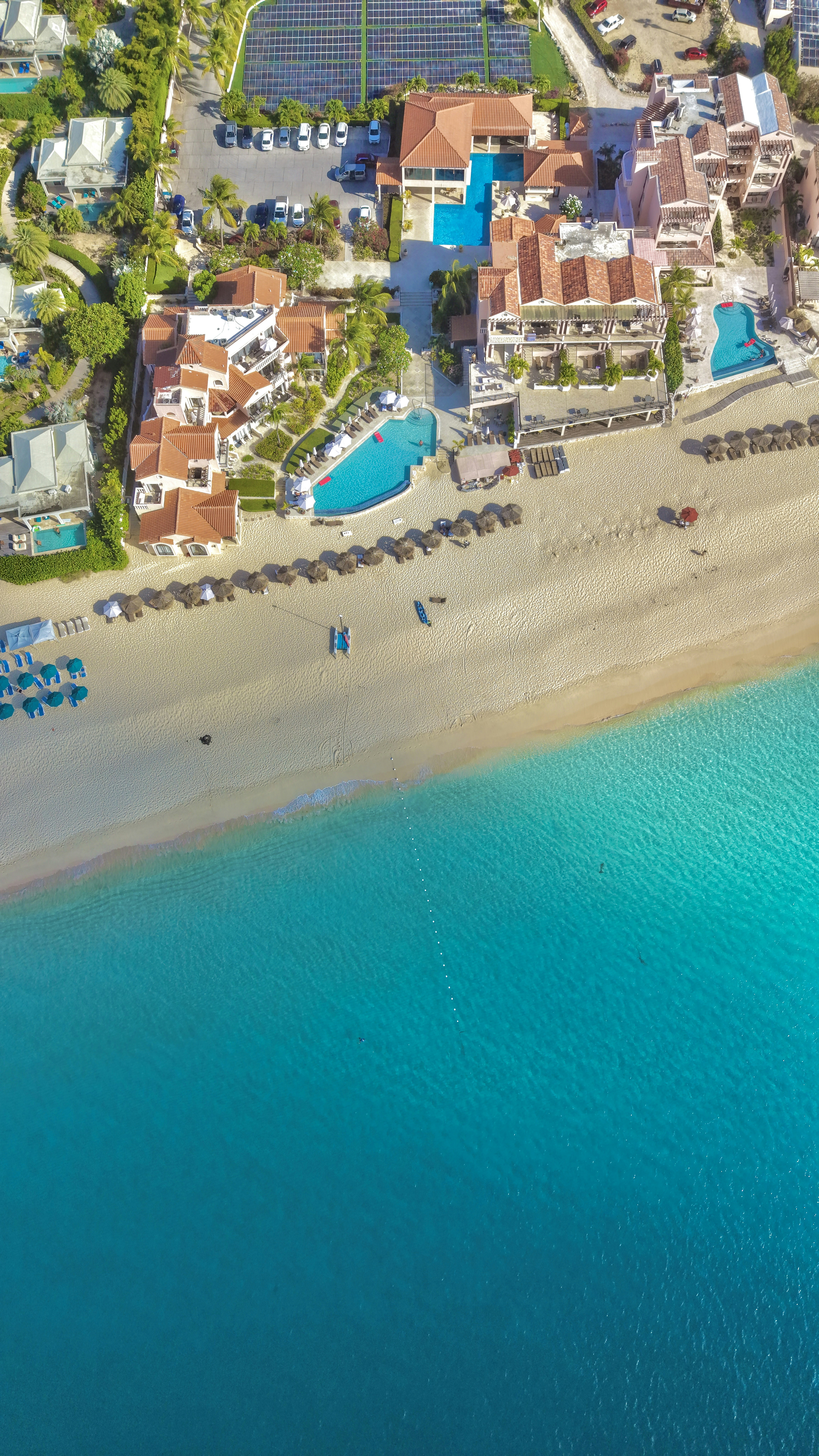Luxury beach resort with pools, sandy beach, and turquoise ocean.