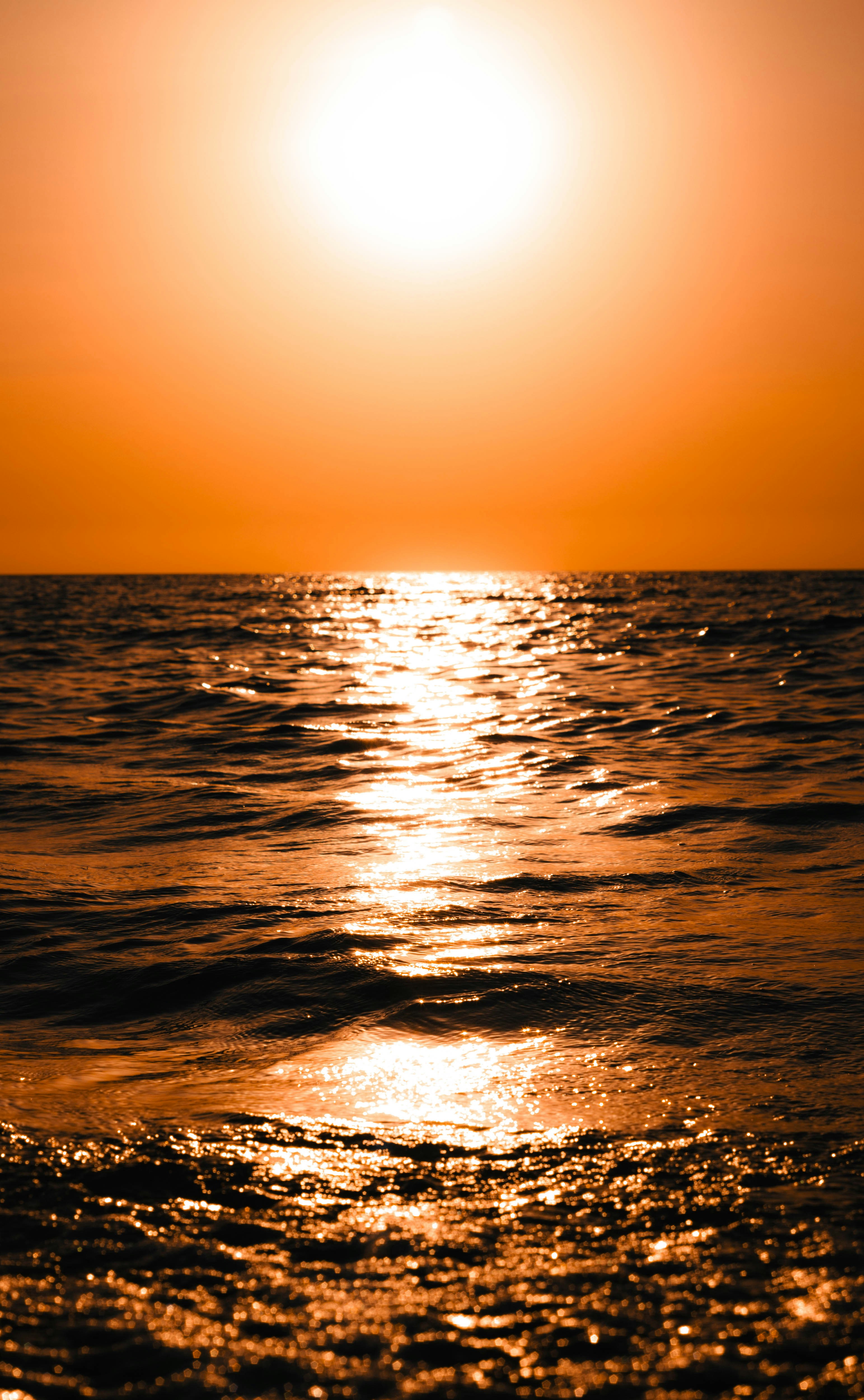 Atardecer dorado sobre olas tranquilas del océano.