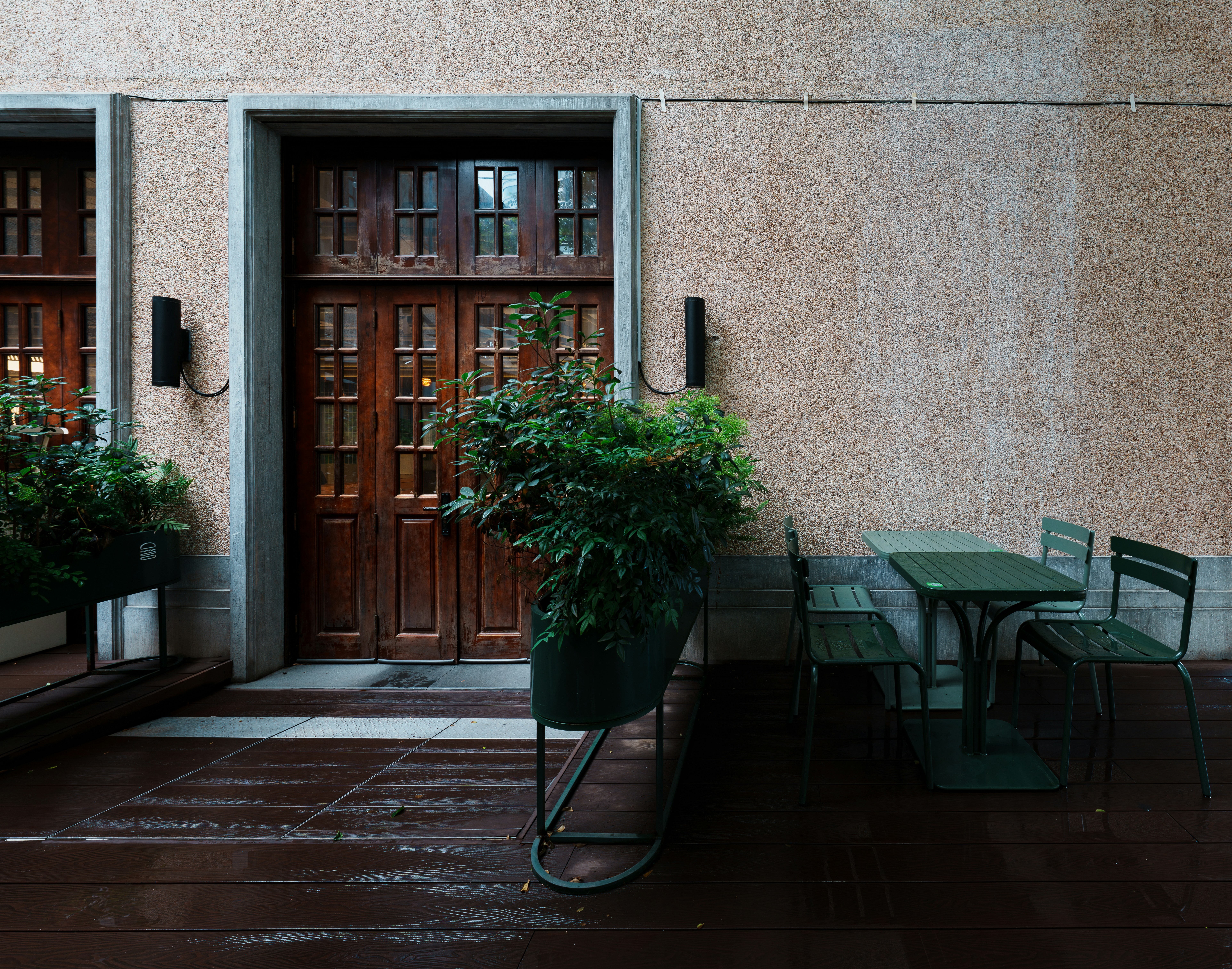 Empty outdoor cafe seating by a wooden door